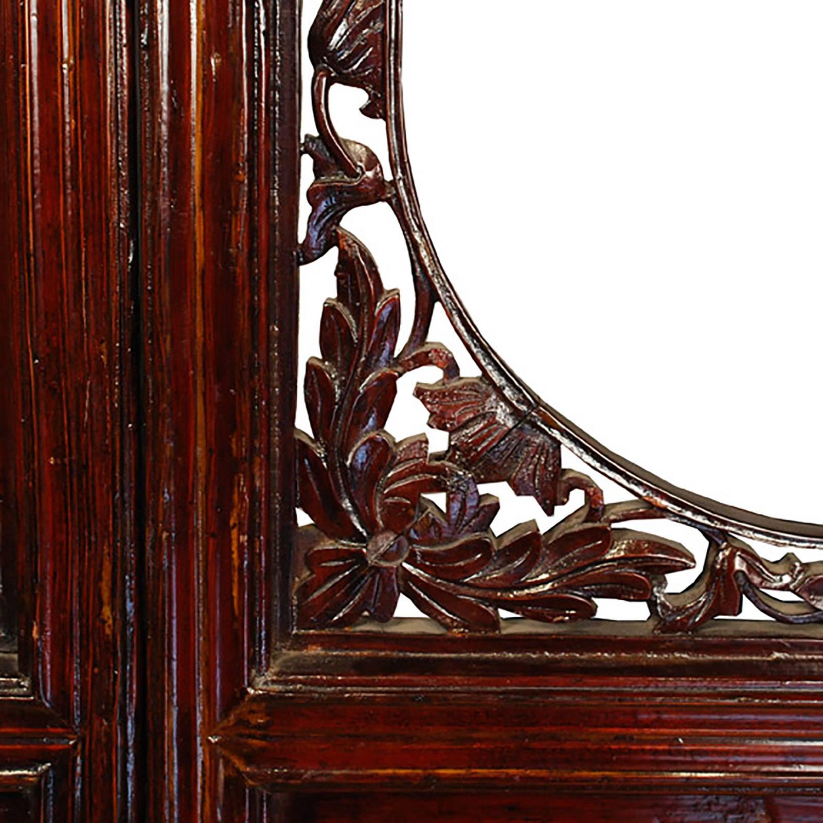 The round openings in the upper panels of these seven elegant 19th century courtyard doors from Canton are surrounded by finely carved floral fretwork backed in mirror. The set of seven evoke life in a traditional courtyard home. Each of the bottom