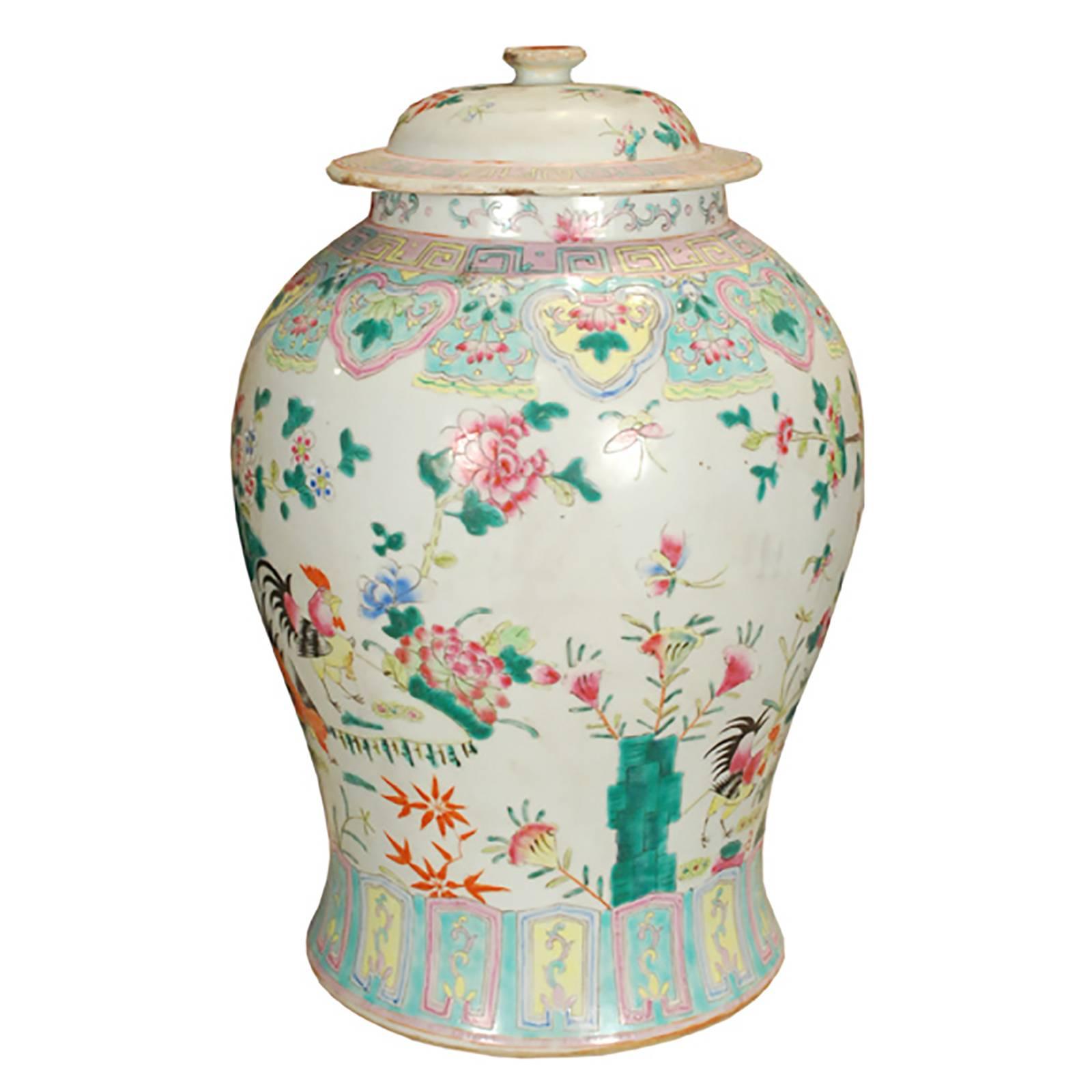 This overglazed porcelain jar from southern China was painted by hand at the turn of the century with roosters in a flowering garden, representing the charms of rural life. This intricate and colorful style of porcelain gained popularity in the