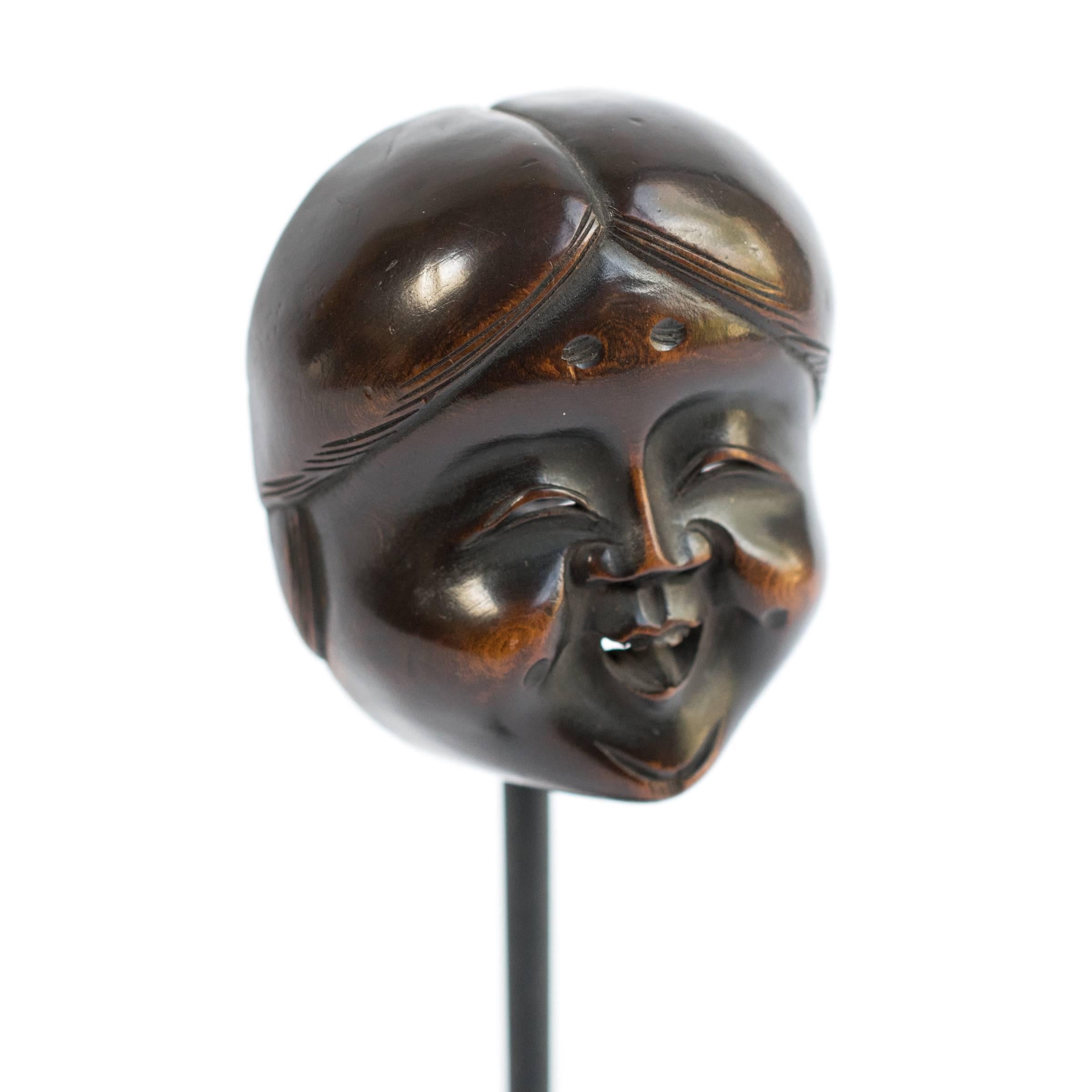 This netsuke (or button-like toggle) would once have hung from the drawstring of a small pouch or bag, which Japanese men wore at their waist. Although it had a practical purpose, this charming bead has exquisite detail and has developed a deep rich