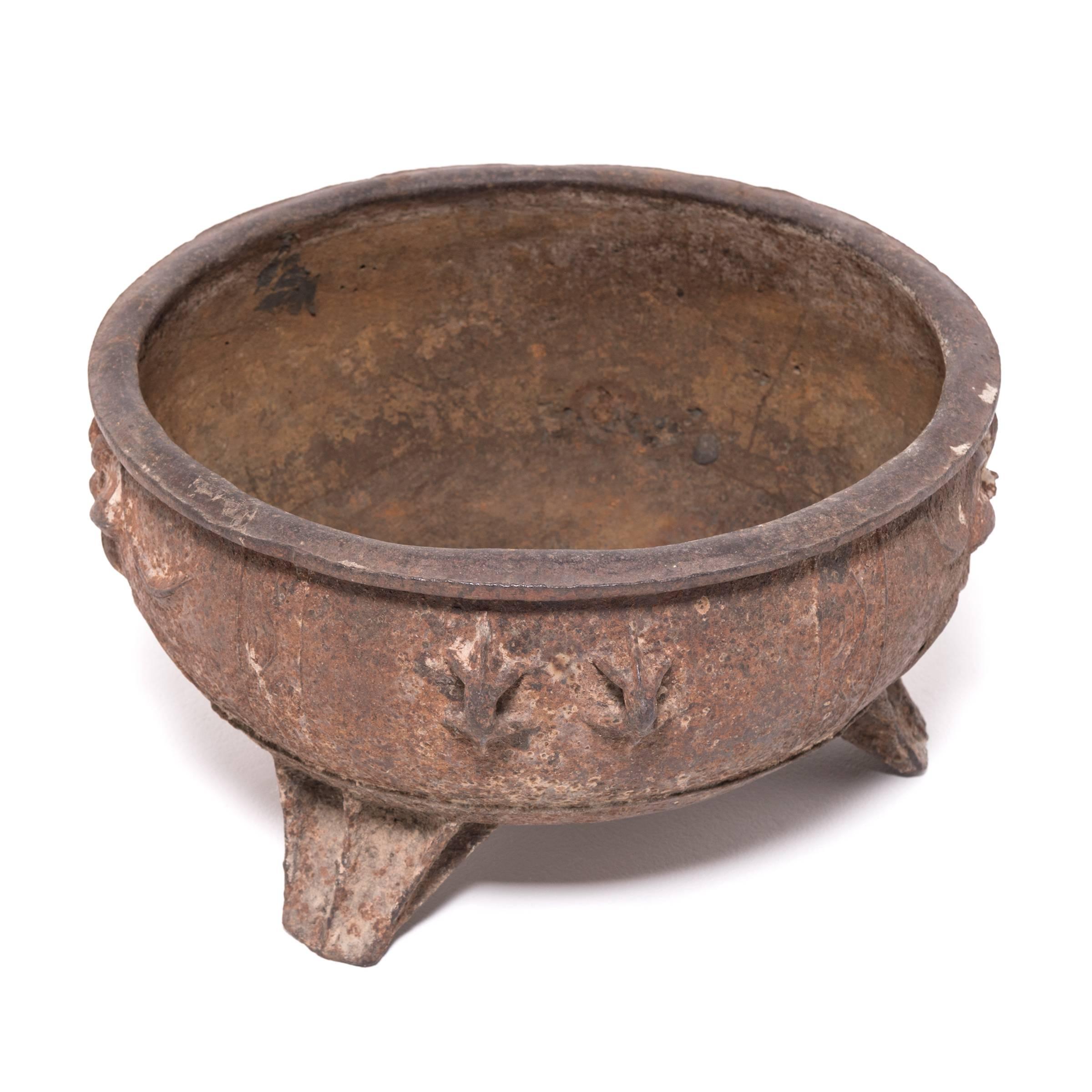 China was the earliest known civilization to make cast iron. It first appeared thousands of years ago during the illustrious Zhou dynasty. Made in the mid-19th century, this low, wide-mouth urn on tripod feet references the earliest forms of cast