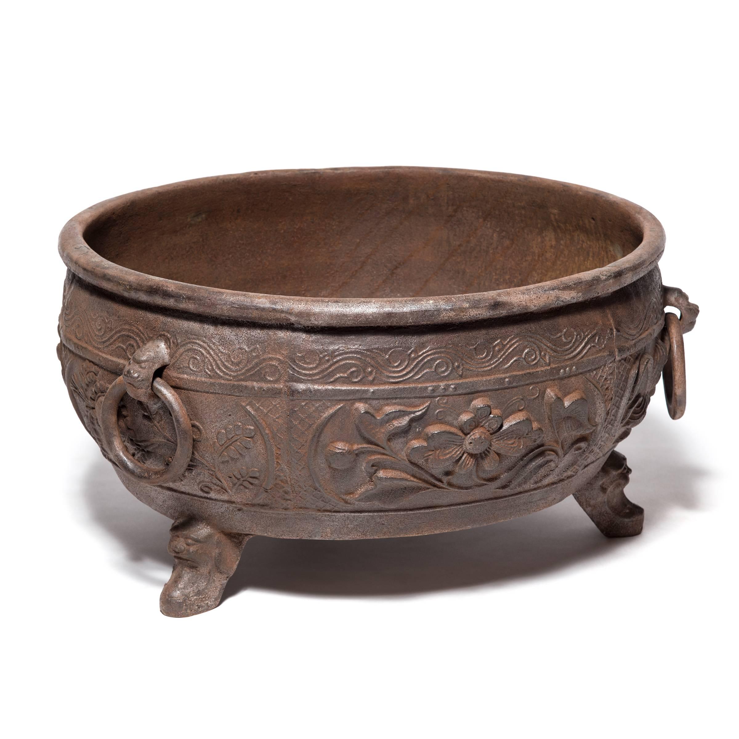 China was the earliest known civilization to make cast iron. It first appeared thousands of years ago during the illustrious Zhou dynasty. Textured with lotus blossoms in high relief and balanced on tripod feet, this contemporary low vessel