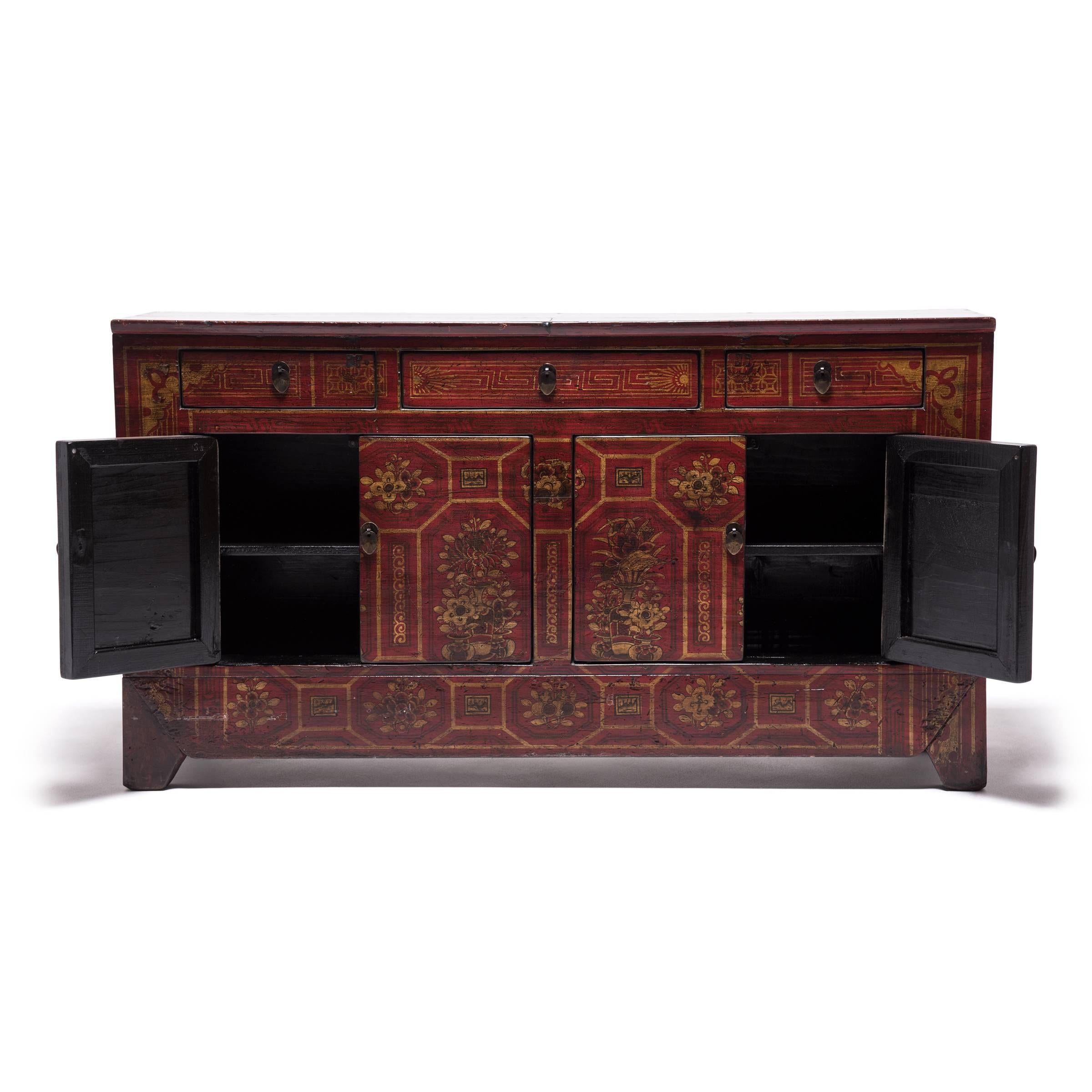 A skilled Mongolian artisan painted this antique pine cabinet with intricate floral designs organized around geometric shapes. Concealed hinges and joinery provide a continuous, flat surface that encouraged its prolific decoration. The cabinet is