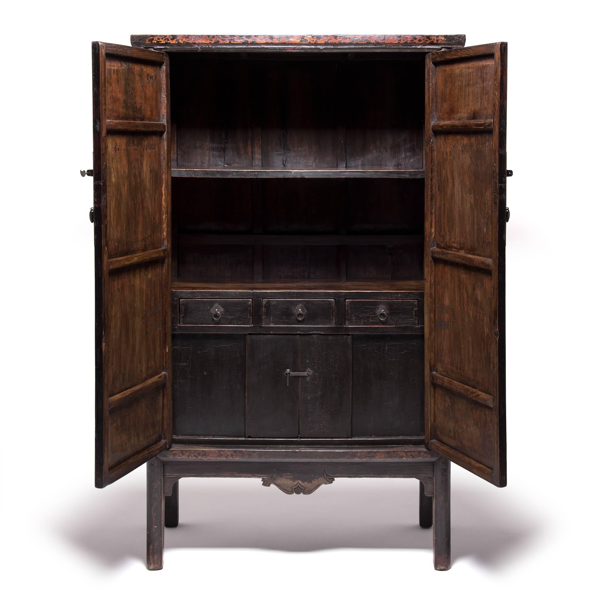 With exceptionally rich lacquerwork, this cabinet bears traces of the original ornate gilt scenery, depicting traditional Chinese palatial courtyard structures in a mountainous park setting. It is framed by intricately scrolled gilt work on the