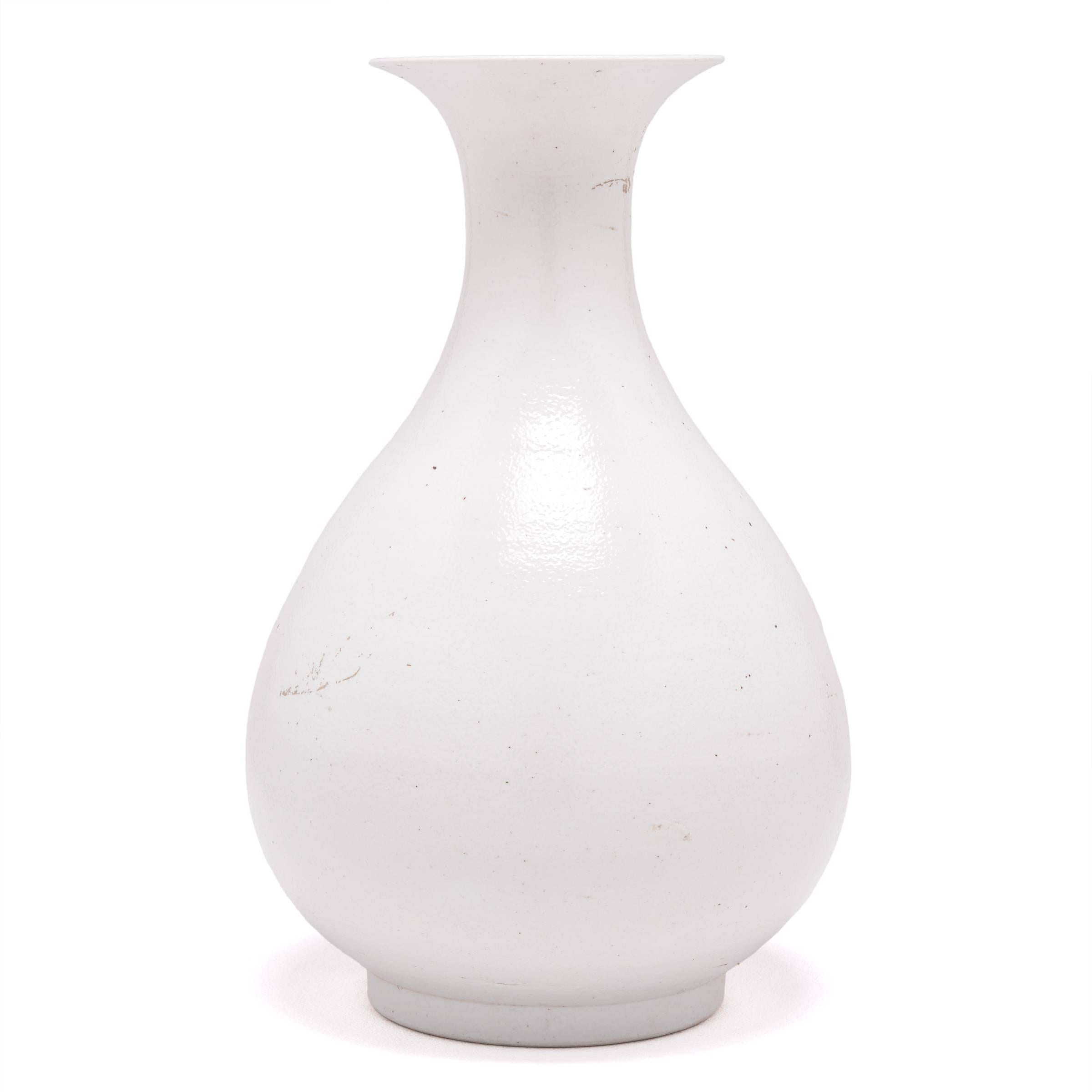 Drawing on a long Chinese tradition of monochrome ceramics, this porcelain vase is cloaked in a cool white glaze to highlight its elegant silhouette. The timeless vase form is known as a yuhuchunping or pear-shaped vase and is defined by a rounded
