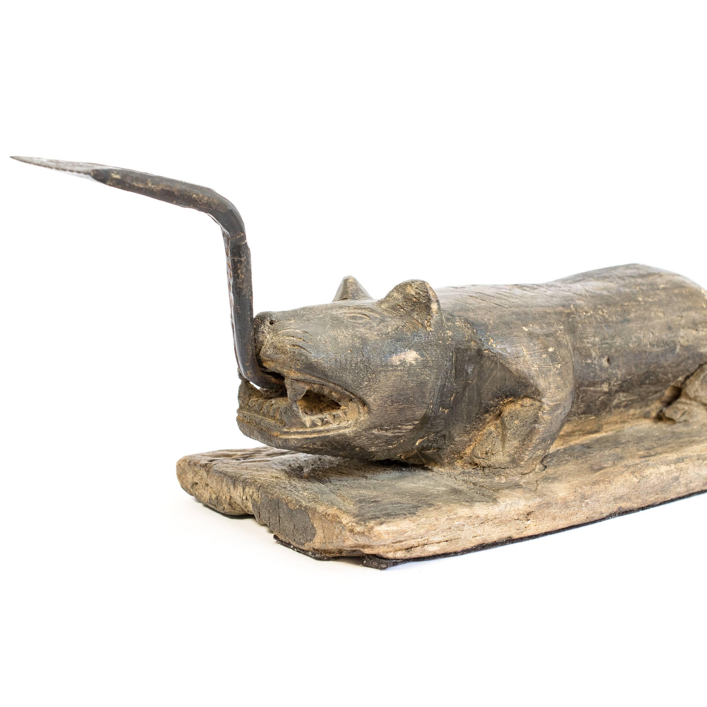 This sculptural early 20th century coconut splitter was carved into the form of a crouching beast ready to pounce. It was likely a merchant's tool in a South East Asian market used to split coconuts which were then ground into fine snow-like flakes
