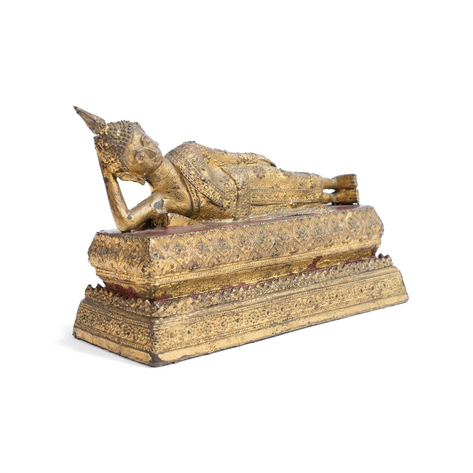 Statues of the Buddha show him either sitting, standing, or as with this gilt bronze figure from Thailand—reclining. When standing he is generally offering a blessing, if he is sitting he is often cross-legged and meditating, but the reclining