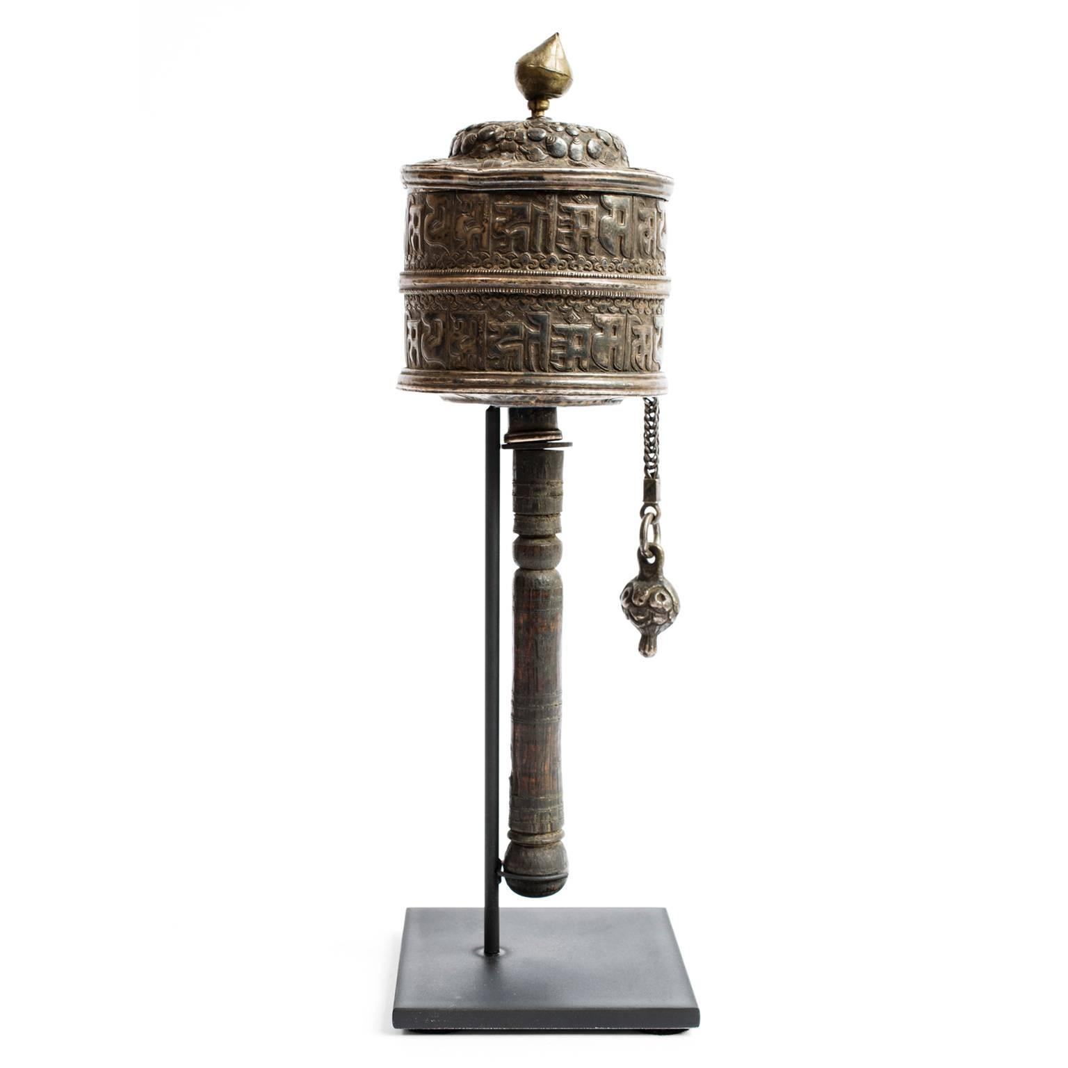 This prayer wheel, made in the early 20th century, is a sacred object to people who practice Tibetan Buddhism. This finely crafted wheel would have been held and spun while chanting a mantra (or prayer). Prayer wheels come in many sizes. Some are