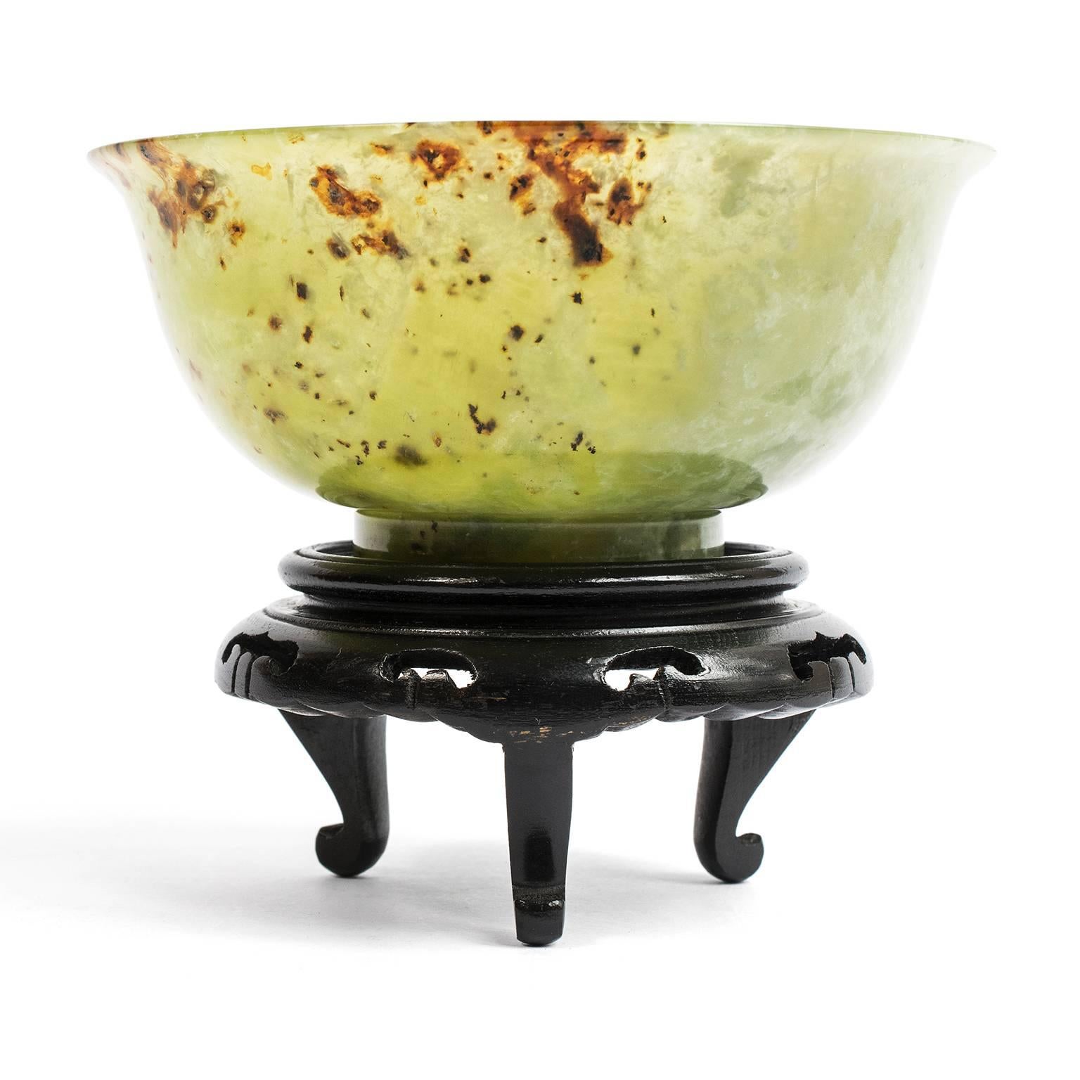 The “spinach green” jade from which this finely shaped bowl was carved has natural russet inclusions offering added beauty and depth to the rich color of this prized stone native to Siberia. This particular jade was a popular import to China during