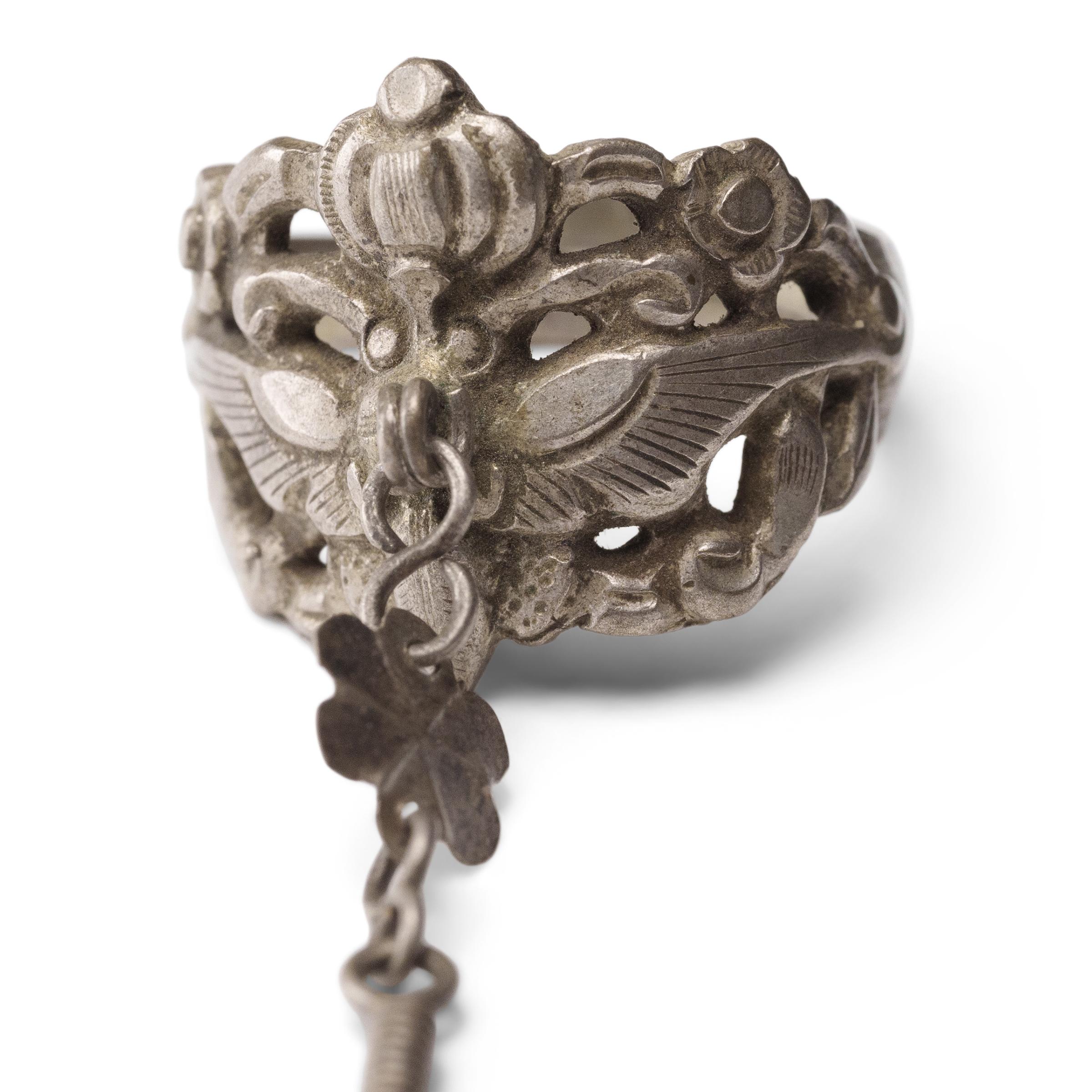 Daté de la fin du XIXe siècle, cet anneau de charme en argent a été fabriqué par les Miao de la province de Guizhou et était censé protéger son porteur de la malchance et des esprits malveillants. L'anneau est décoré d'un motif percé en bas-relief