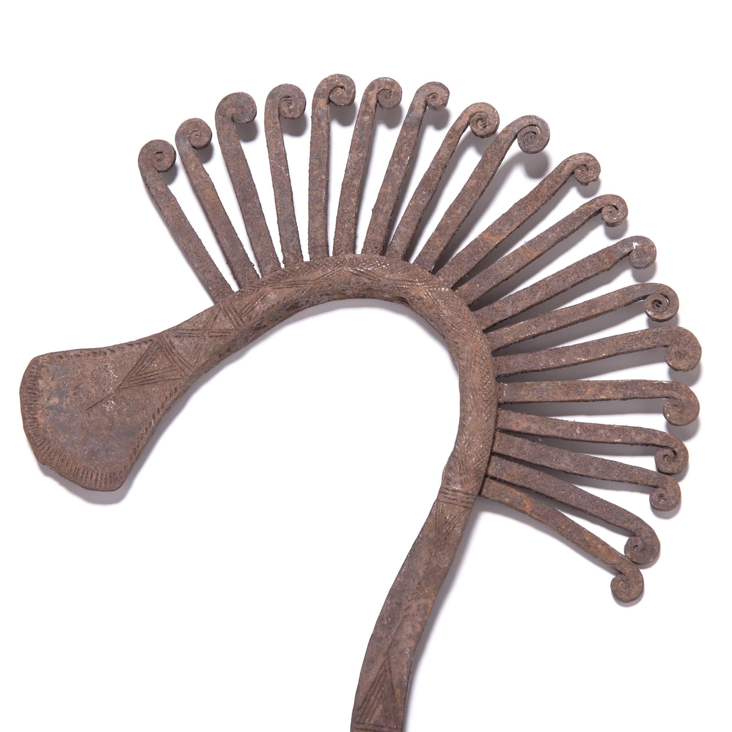 For hundreds of years before colonization, African tribes elevated everyday objects to create multi-use currency. The exotic bird's head design of this iron staff currency calls to mind flocks common to the northwestern reaches of Cameroon. Valued