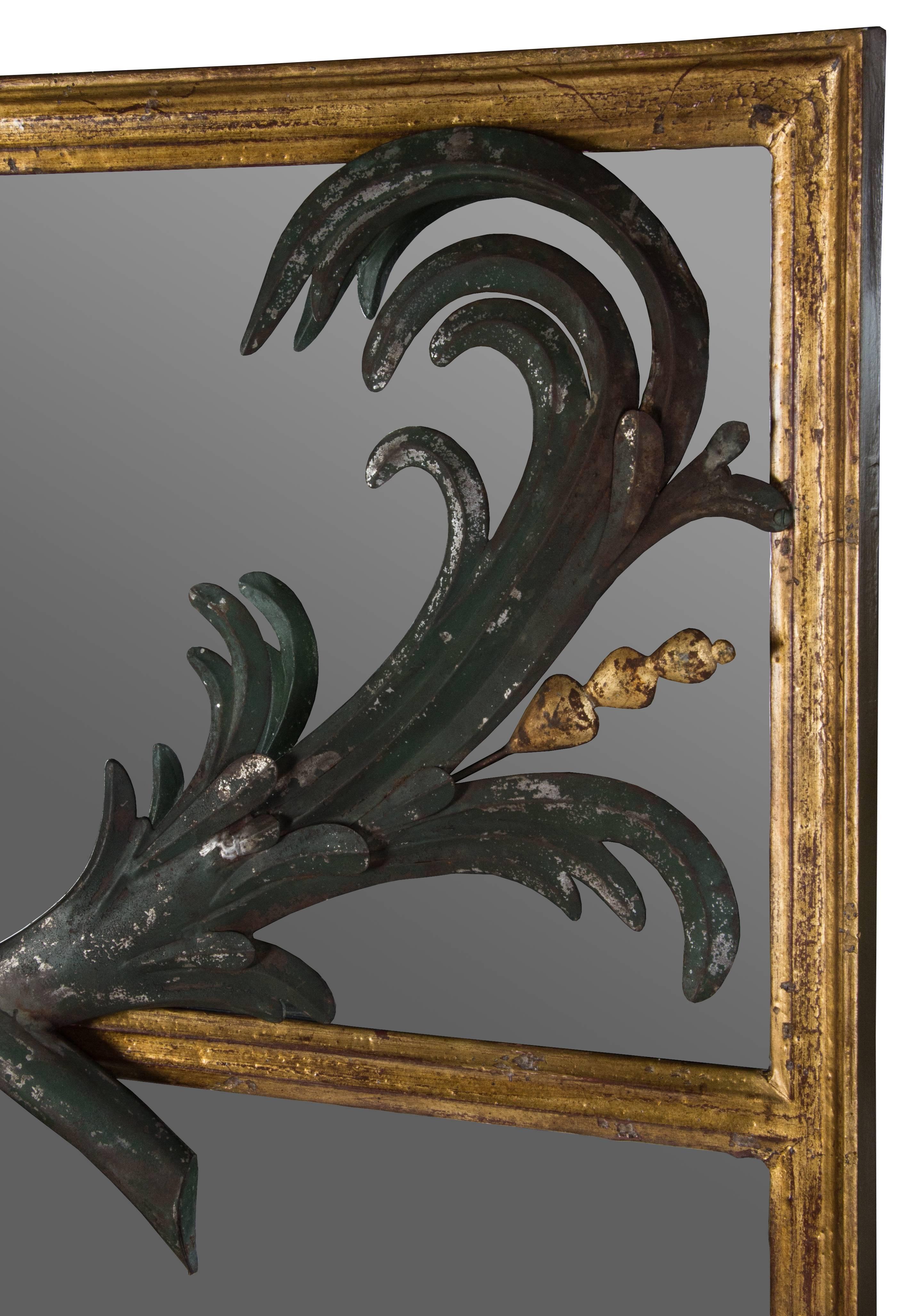 This is an interesting gilt metal trumeau mirror, having stylized enameled dark green metal fronds each accented with gold stamens.