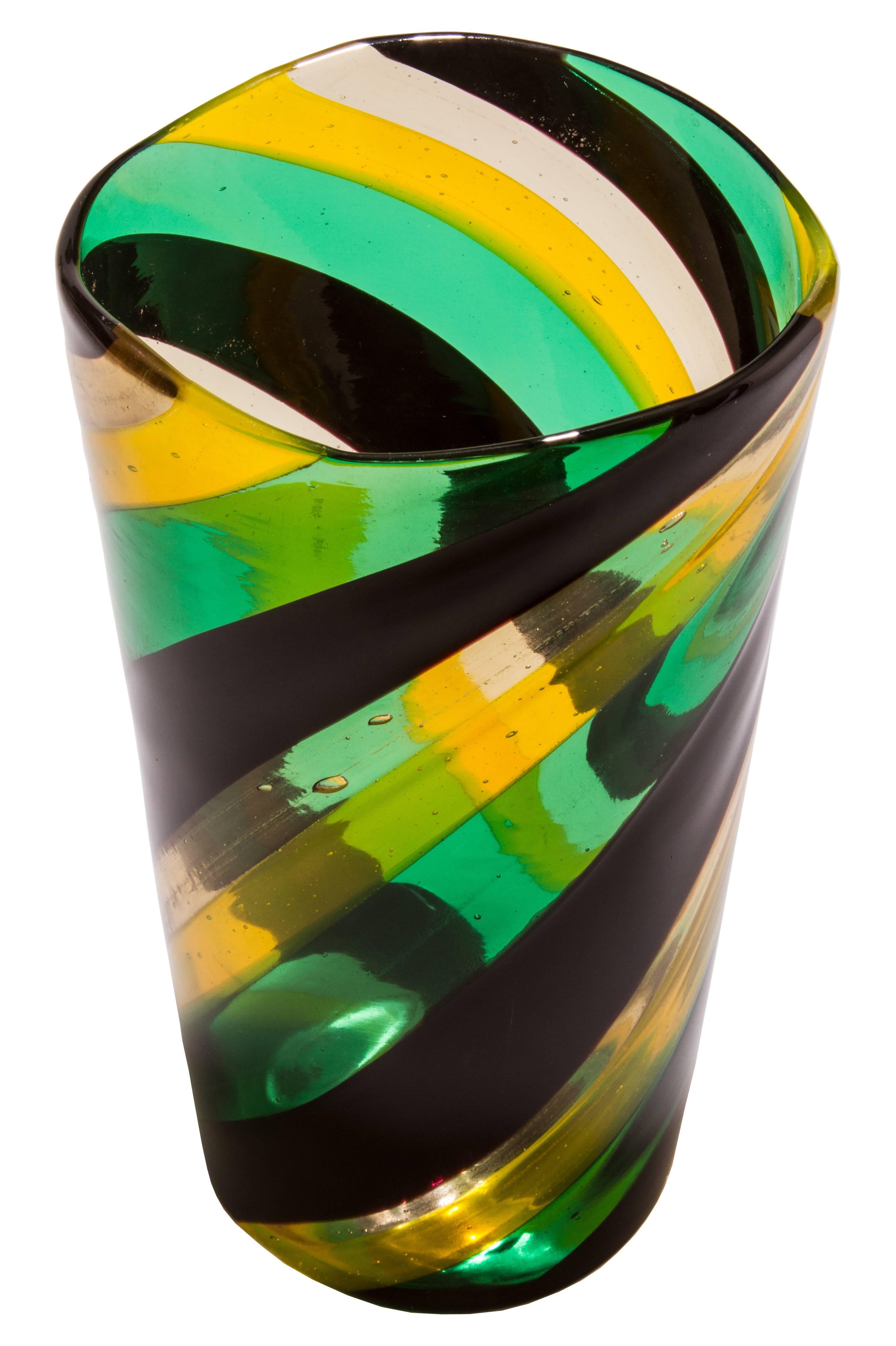 Fulvio Bianconi used fused ribbons of glass in clear yellow, green and black to create this optical vase. It is acid stamped Venini Murano.