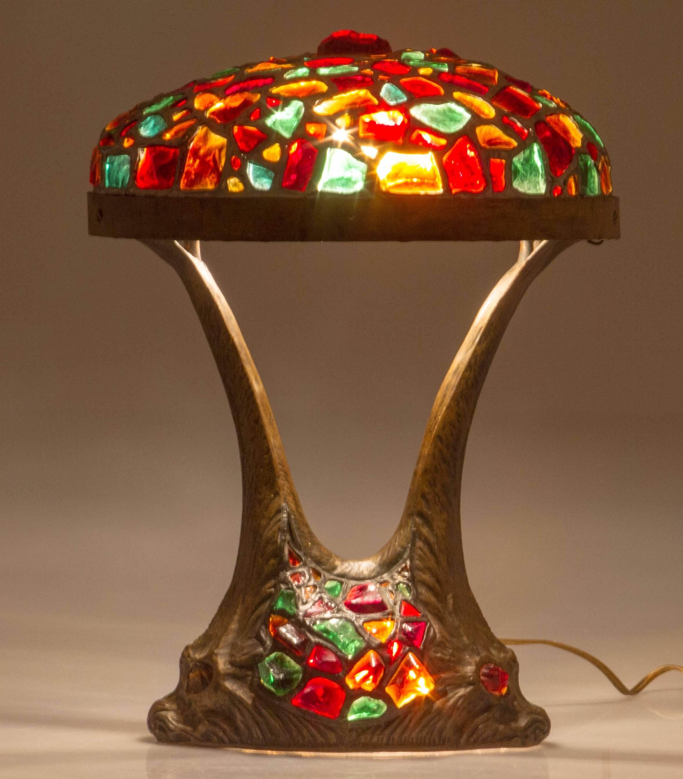 Lighting from both the base as well as the shade, this is an unusual and beautiful lamp. Highlighting the chunk glass elements two glass eyed dolphins support the shade.