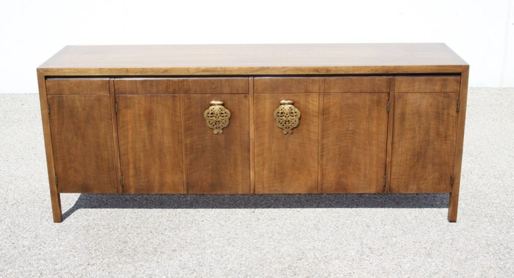 Asiatisch-modernes Sideboard von Bert England für Johnson Furniture Company. Trendiges Sideboard aus Nussbaum mit großen Messingbeschlägen an den mittleren Türen. Der Preis beinhaltet die Nachbearbeitung, die 10-14 Tage in Anspruch nehmen kann. Ich