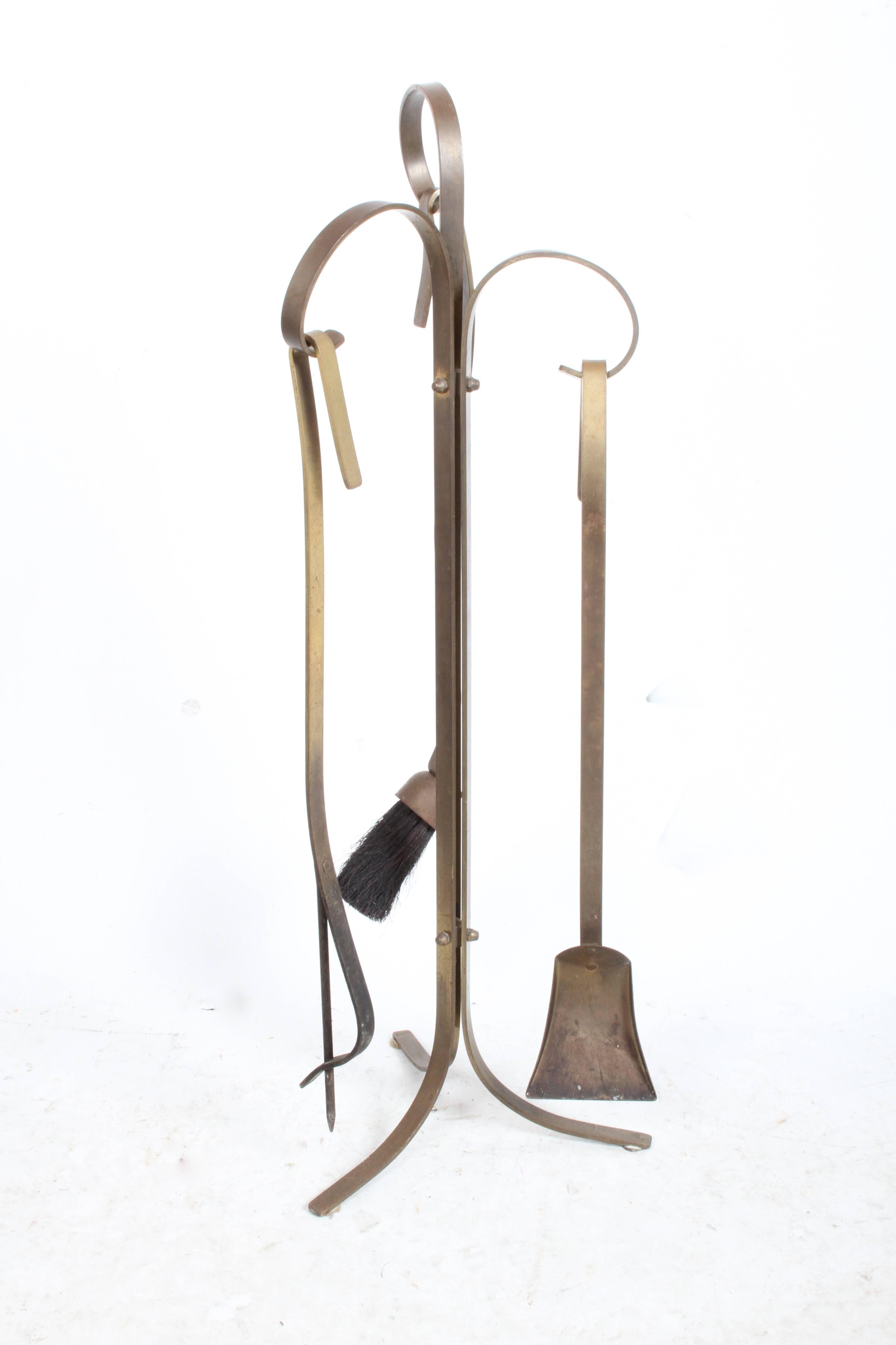 Set di attrezzi da fuoco scultorei in ottone degli anni '50 circa, con patina originale. Può essere lucidato con un costo aggiuntivo.  Il set include strumenti per il fuoco, androni e porta ceppi. 

Strumenti 35,5 h x 12d. 
Androni 16h x 7w x