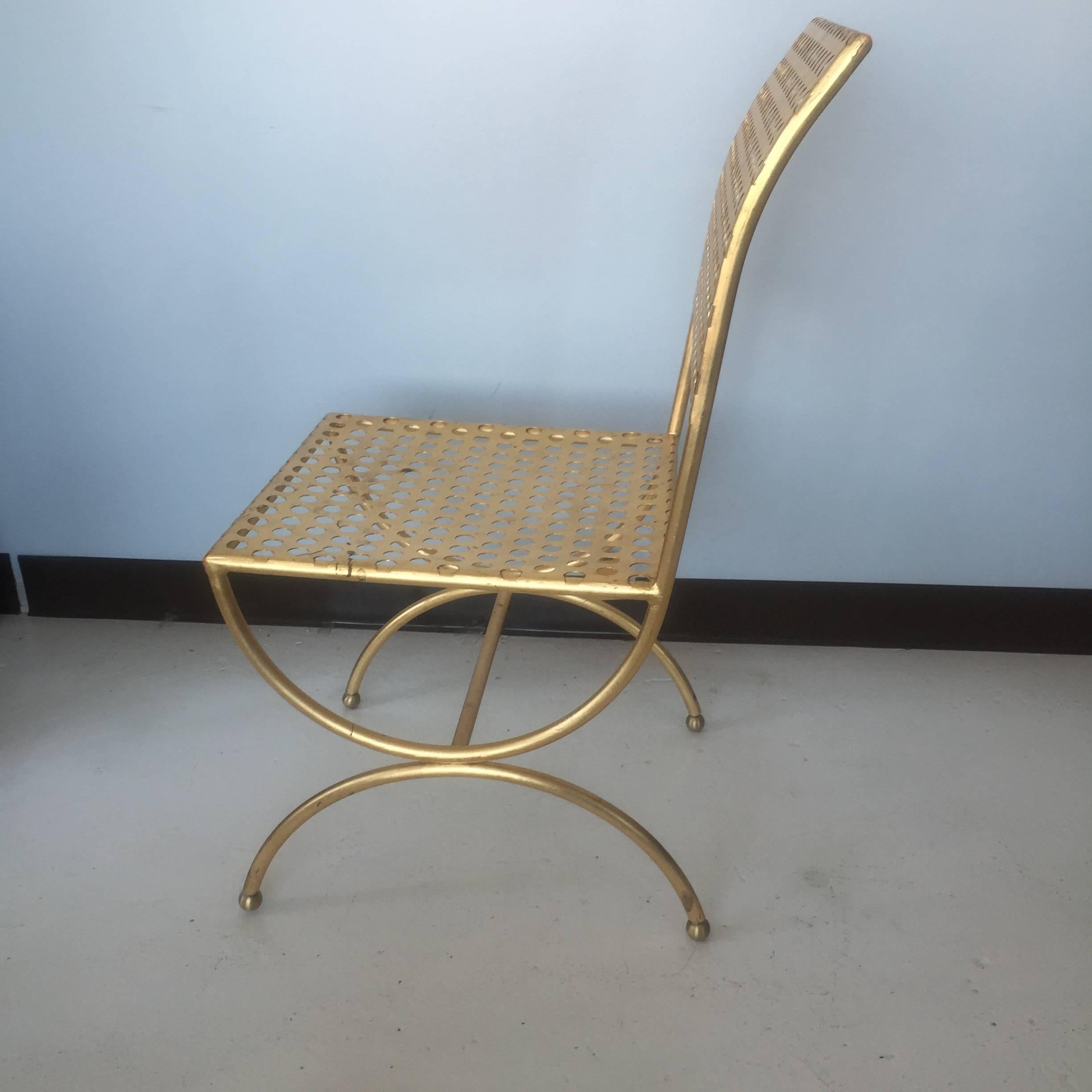 Perforated gilt iron chair designed by Tony Duquette in the 1960s, produced for Baker circa 2011.