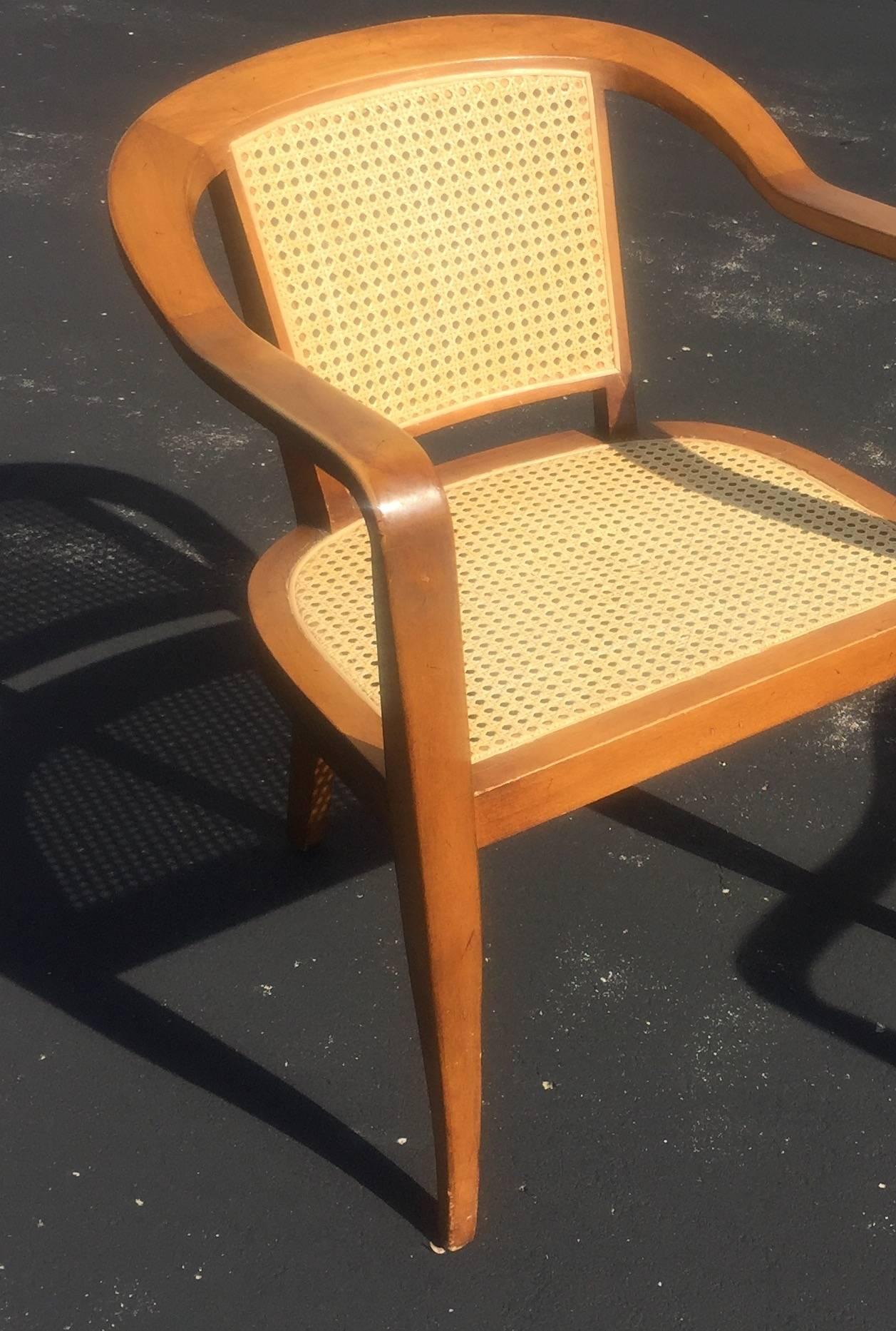 Pair of 1950s Mid-Century Modern armchairs, cane inset seats and backs on walnut frames with splayed legs. In the style of Edward Wormley for Dunbar.