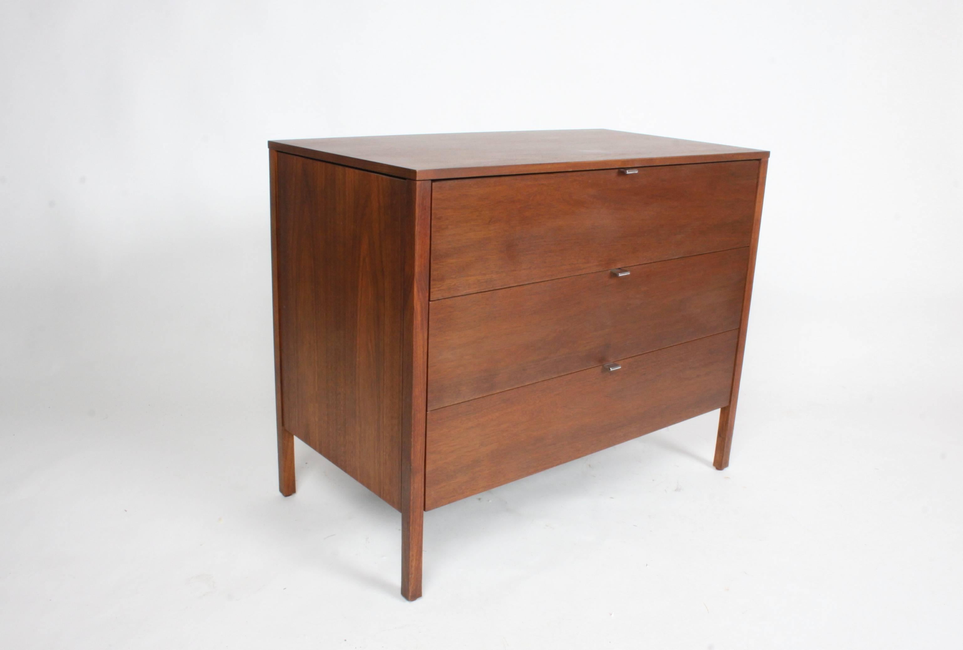 Pair of early walnut Florence Knoll chests or nightstands. Comes with third middle section that forms a dresser vanity or desk. Early label. Tops have been refinished, cabinets have restored original finish. The overall width including middle