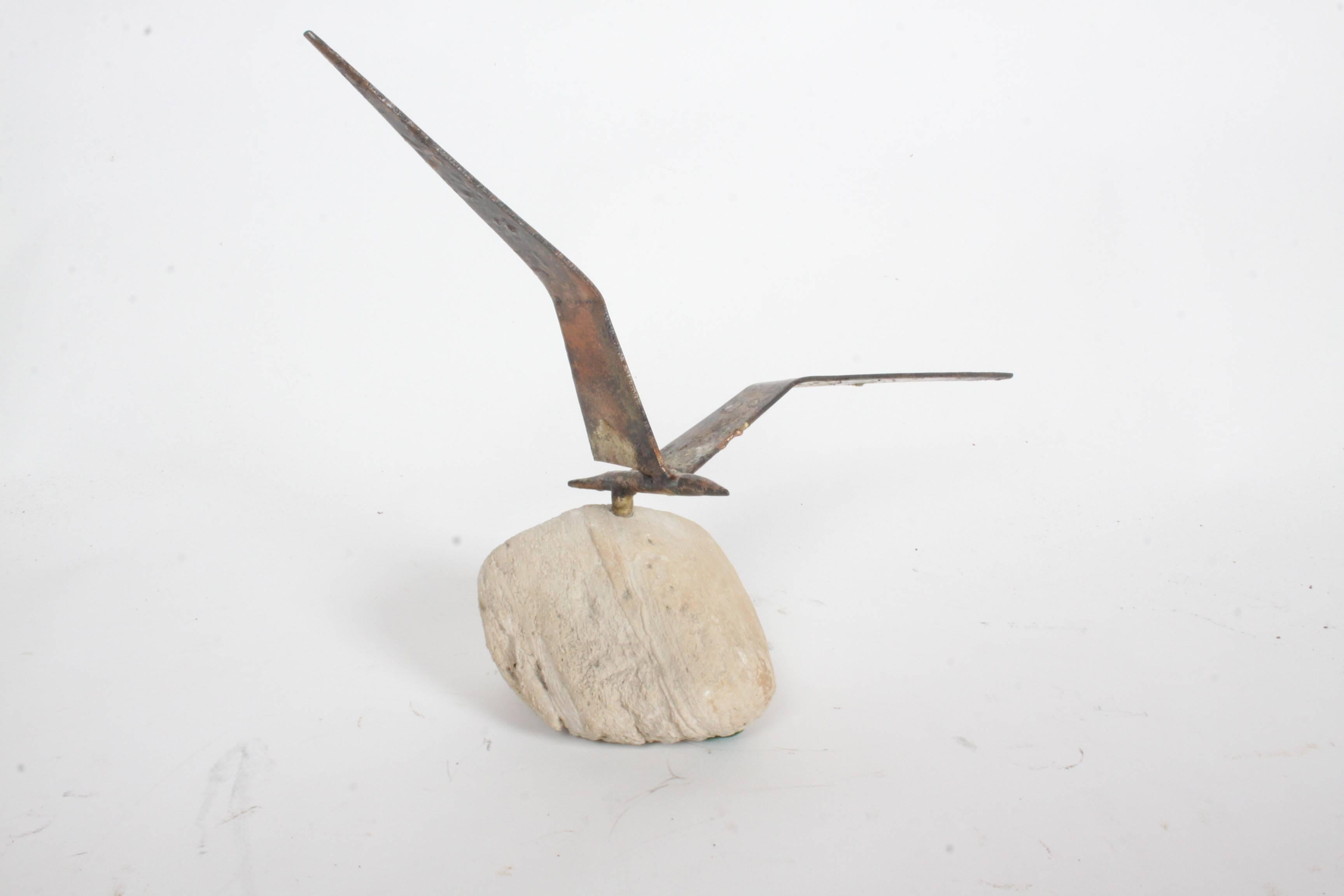 Oiseau en vol en métal 'Curtis Jere', datant des années 1960, en patine appliquée, sur socle en pierre.