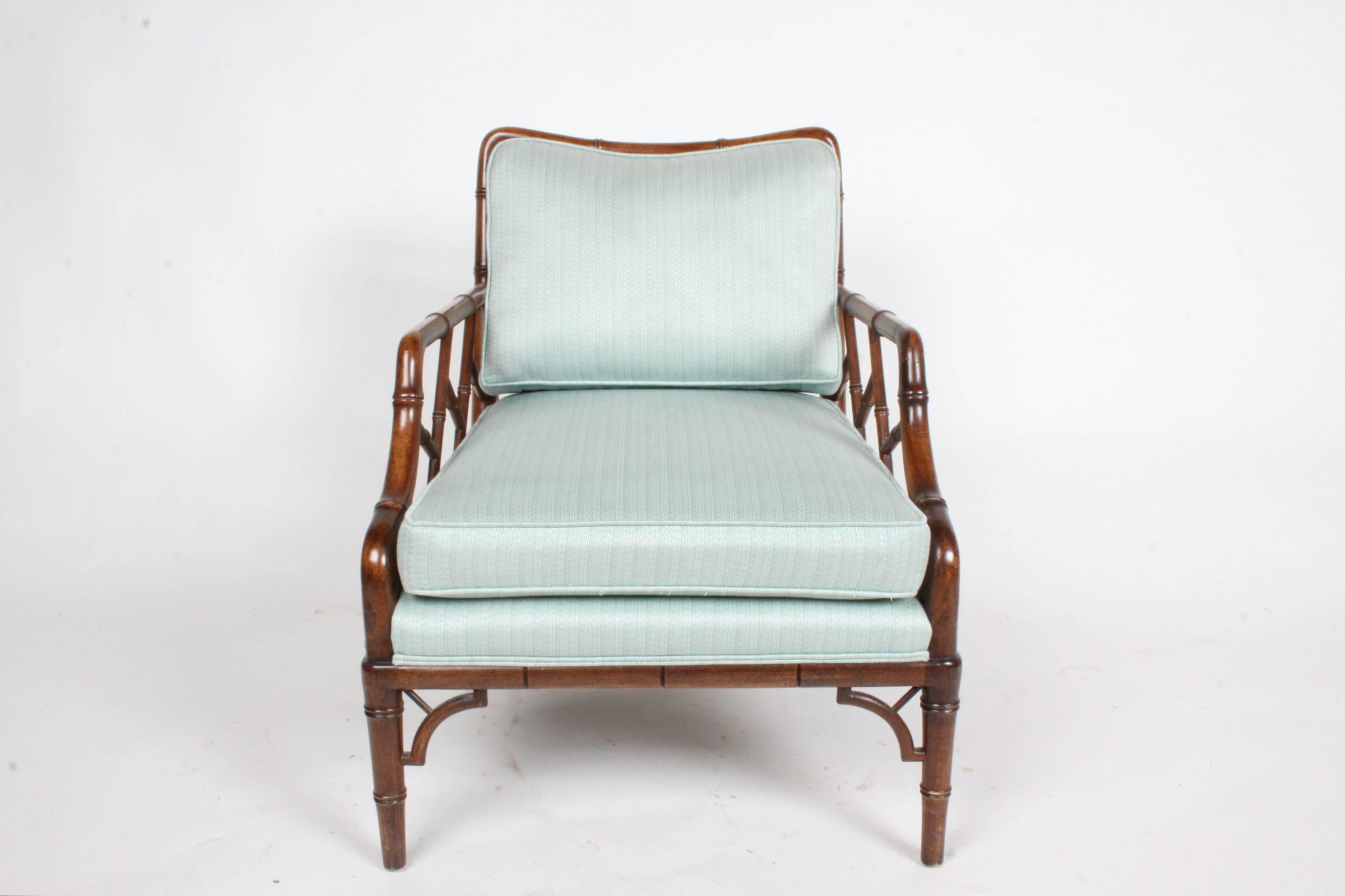 Pair of faux bamboo Chinese Chippendale lounge chairs in the style of T.H. Robsjohn-Gibbings. Foam and upholstery was updated in recent years. Fabric is clean. Seat depth 21".