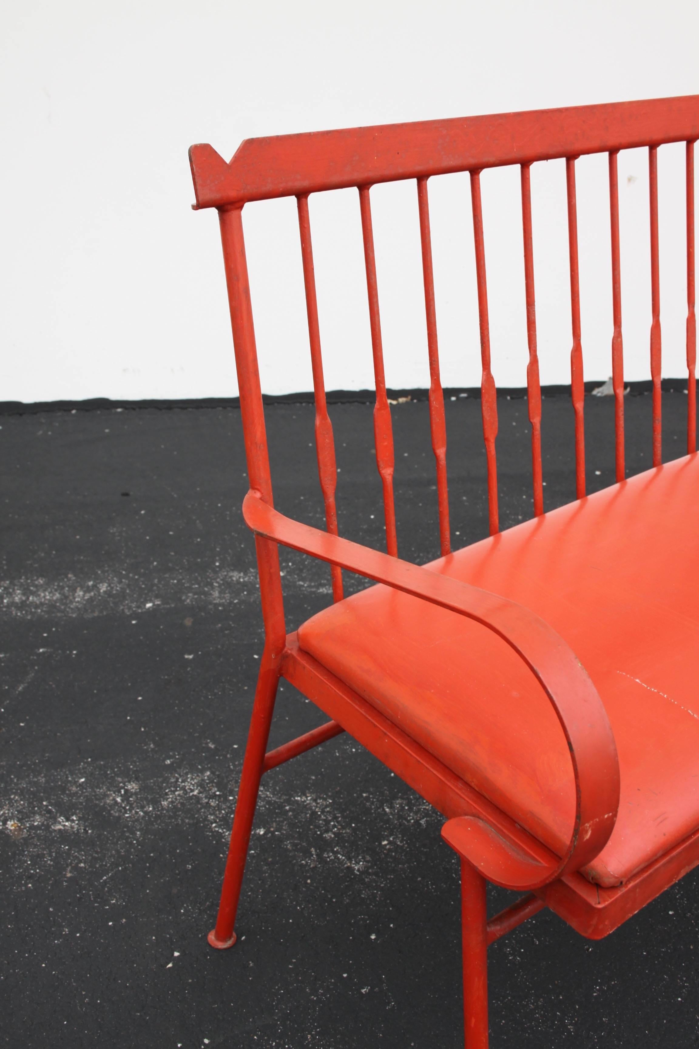 Super cool 1950s wrought iron Shaker influenced iron bench or settee in the style of designer Kipp Stewart. Painted in a vibrant red, paint does show some age, seat cover was painted too and needs to be replaced as it is cracking. Possibly made by