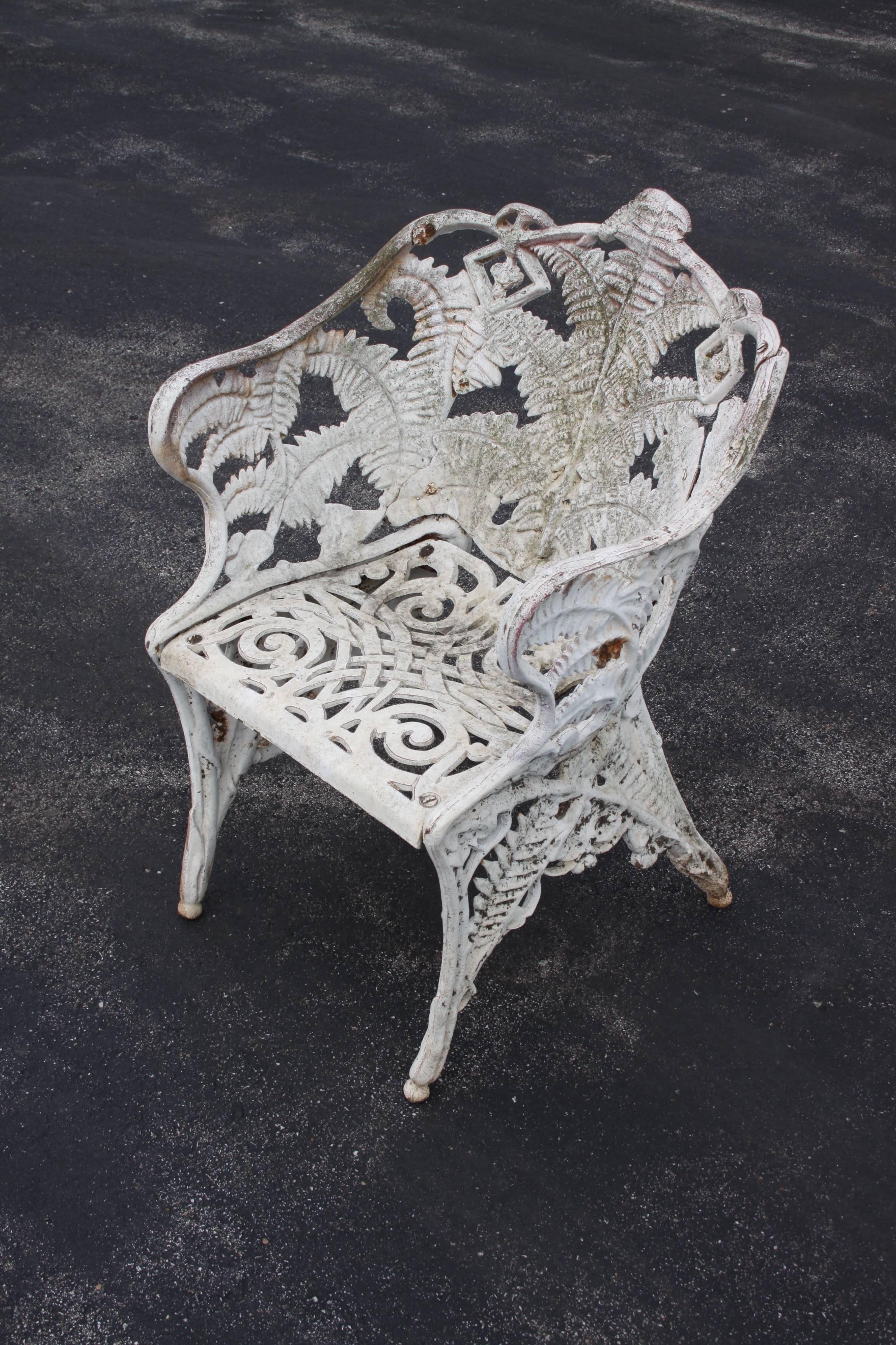 Pair of early 20th century cast iron fern pattern garden chairs from an 144 year old Historic St. Louis home. Paint shows signs of age, wear and rust. Can be blasted, dipped and repainted for $125 per chair.