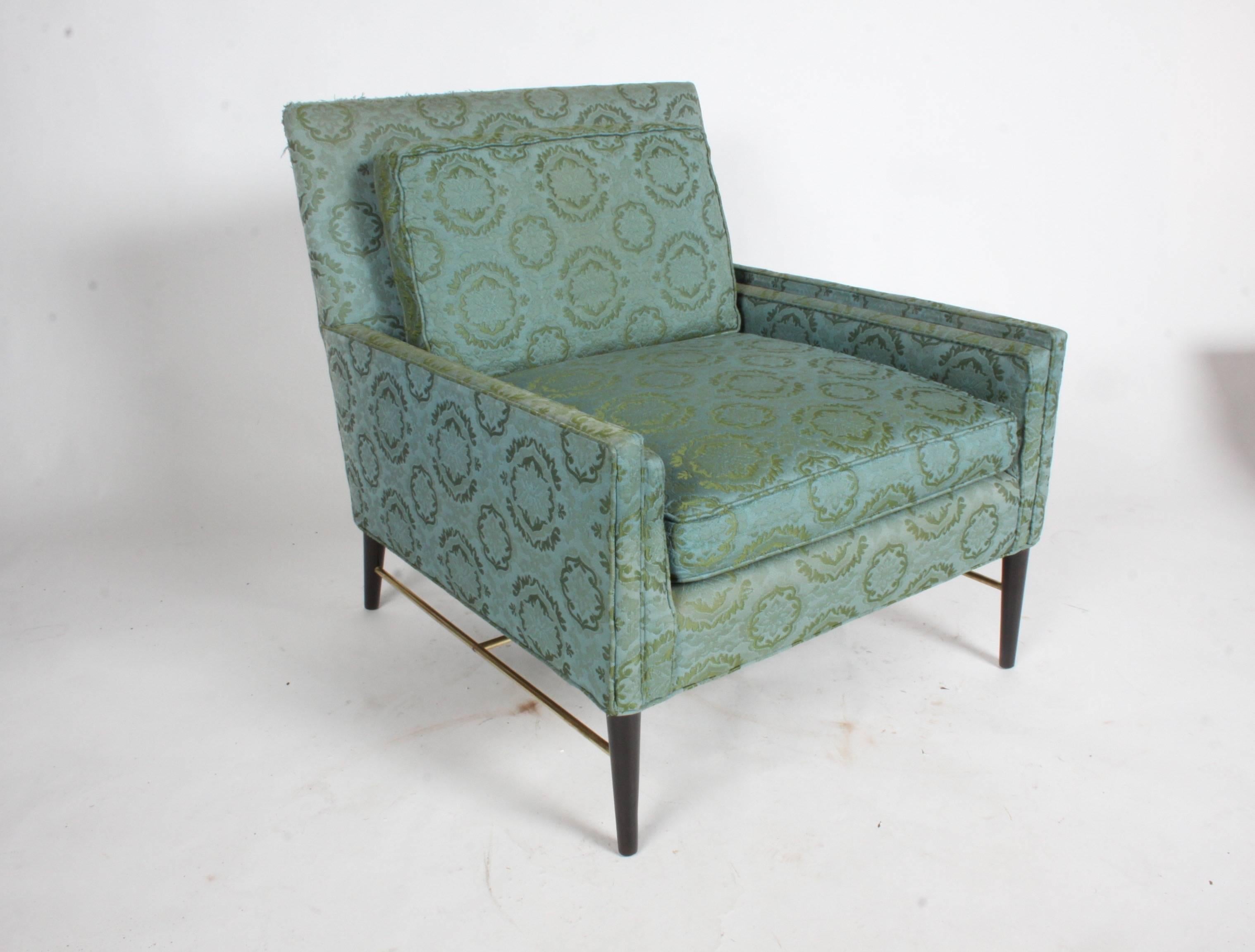 Pair of Paul McCobb for Calvin lounge or club chairs in the original fabric with brass stretchers and tapered mahogany wood legs. The brass has been polished and the legs refinished in a dark espresso finish. Upholstery and foam are original, shows