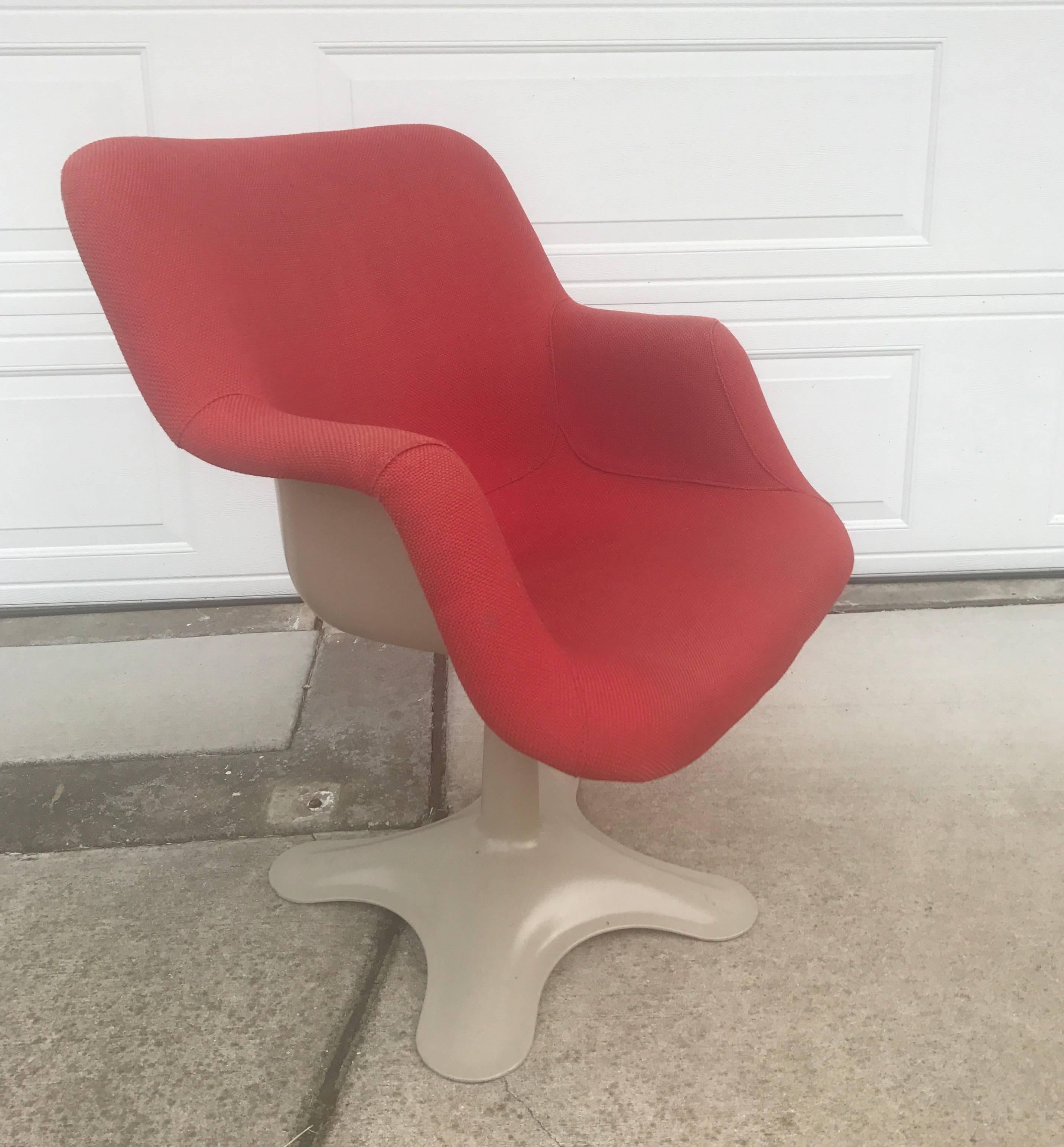 Yrjö Kukkapuro molded fiberglass swivel armchair in organic shape with red woven fabric. Fabric shows some moderate fading and age. Fabric is presentable but you would want to reupholster for it to be pristine. No chips to fiberglass, minor scuffs.