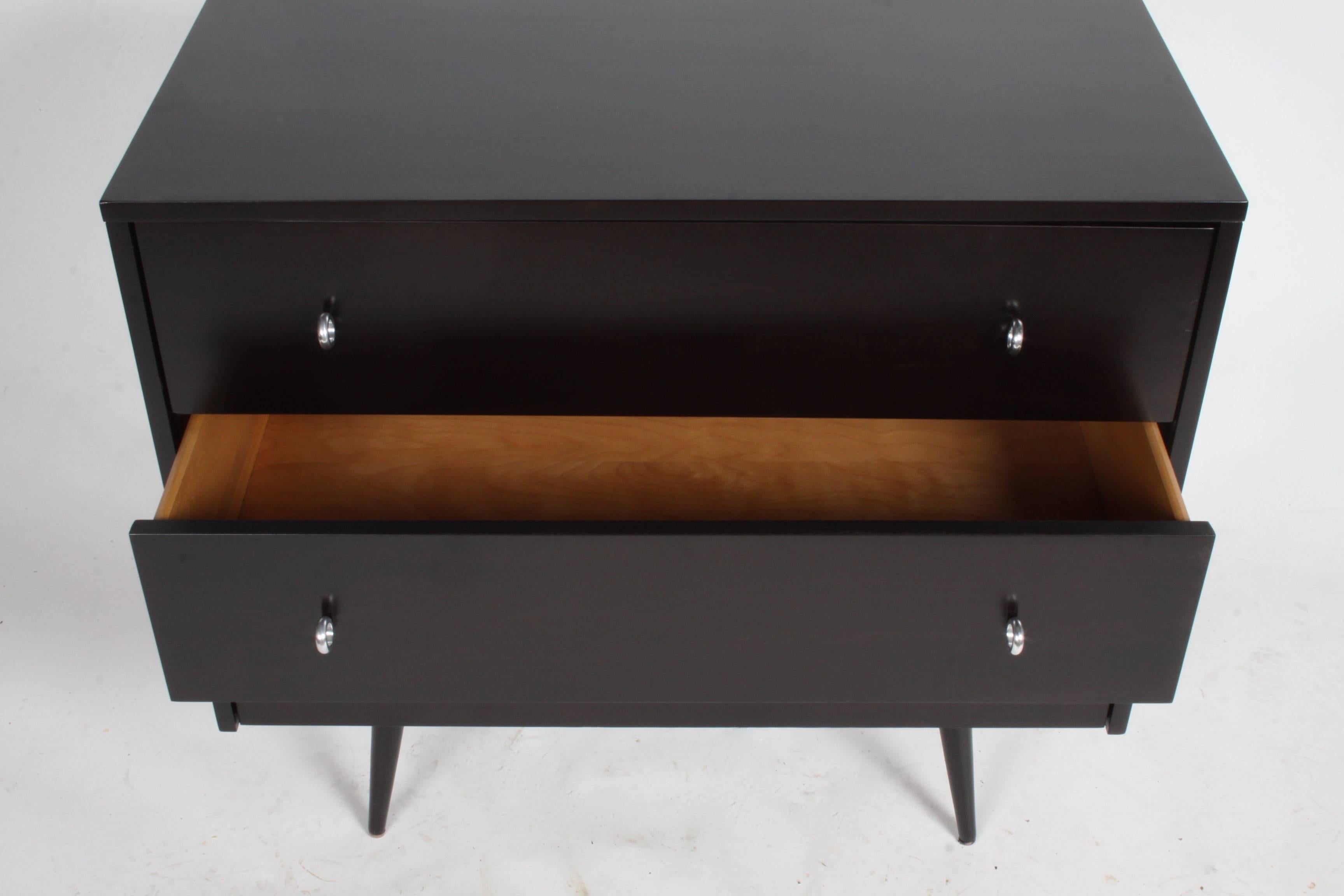 Pair of Paul McCobb Planner Group chests or dressers, circa 1950s. Completely restored and refinished in a dark ebony finish, with original aluminum round ring pulls on taper legs. Excellent condition.