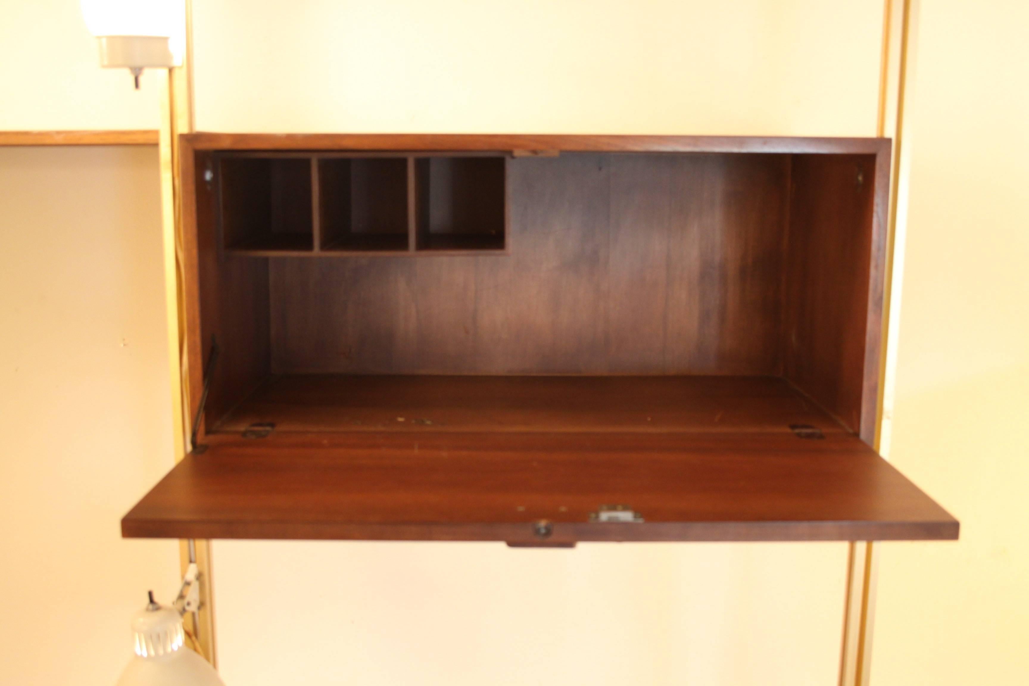George Nelson designed 1950s wall and desk unit for Omni. Three sections with writing desk and drawers, storage cube, book shelves and lights. Sold with three lights, two of the lights are missing the original globes. Will be shipping without the