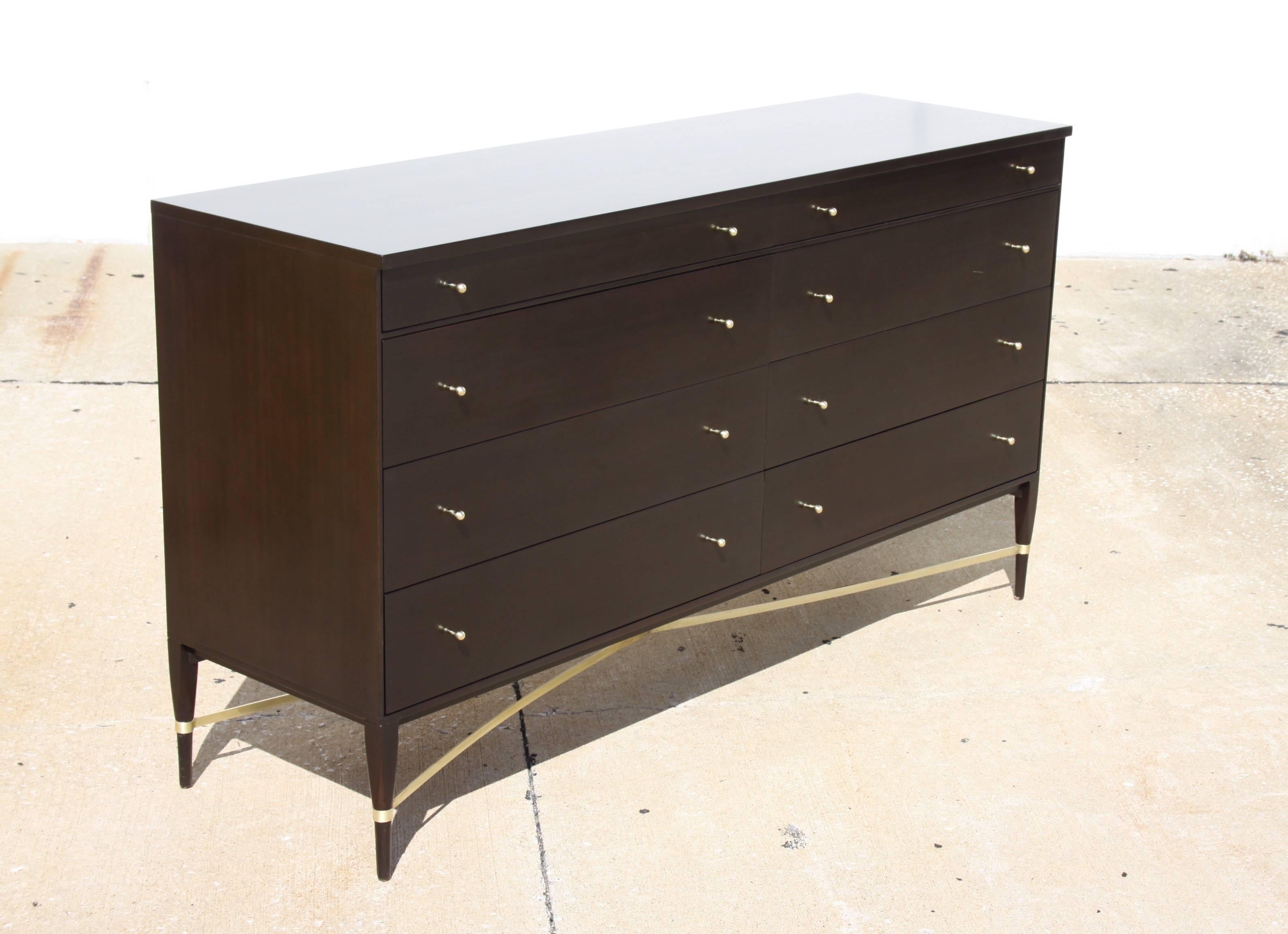 Paul McCobb for Calvin Group fully restored eight-drawer dresser with brass cross stretcher. Mahogany refinished in espresso, original knobs butler brass plated and brass X-base polished. This version is rarely seen, can also be used as a sideboard.