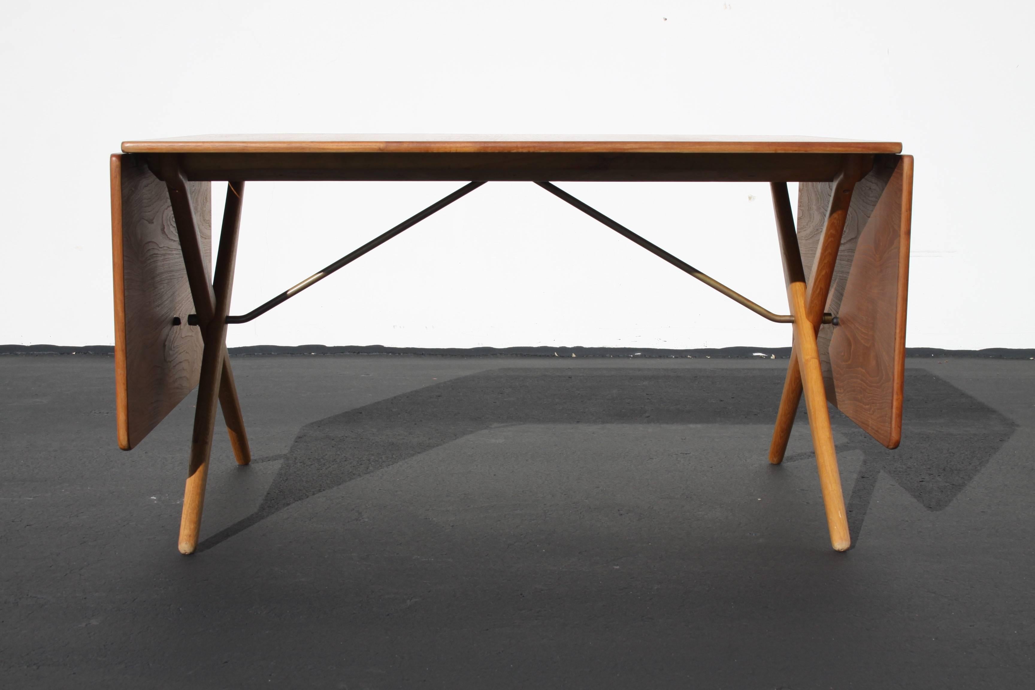 Vintage Danish modern Hans Wegner model AT-309 teak and oak drop leaf dining table. Beautifully restored top and X-legs with great original patina to the brass. Stamped with makers mark Fabrikat: Andreas Tuck, Arkitekt: Hans J. Wegner Denmark. Fully