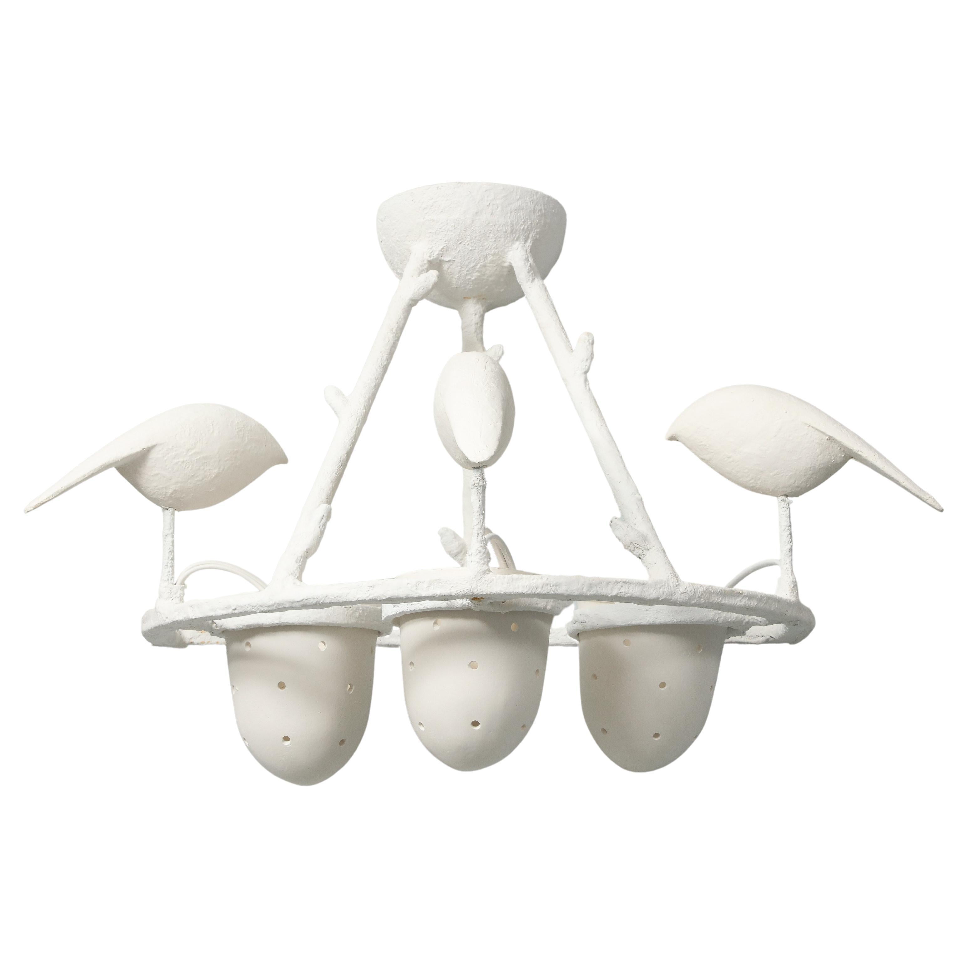 These four sconces designed by Jacques Darbaud continue the tradition of  Giacometti's flora and fauna. Here we have birds who perch on a  frame and peck in a porcelain perforated cup which holds the bulb. The structure is in metal covered with