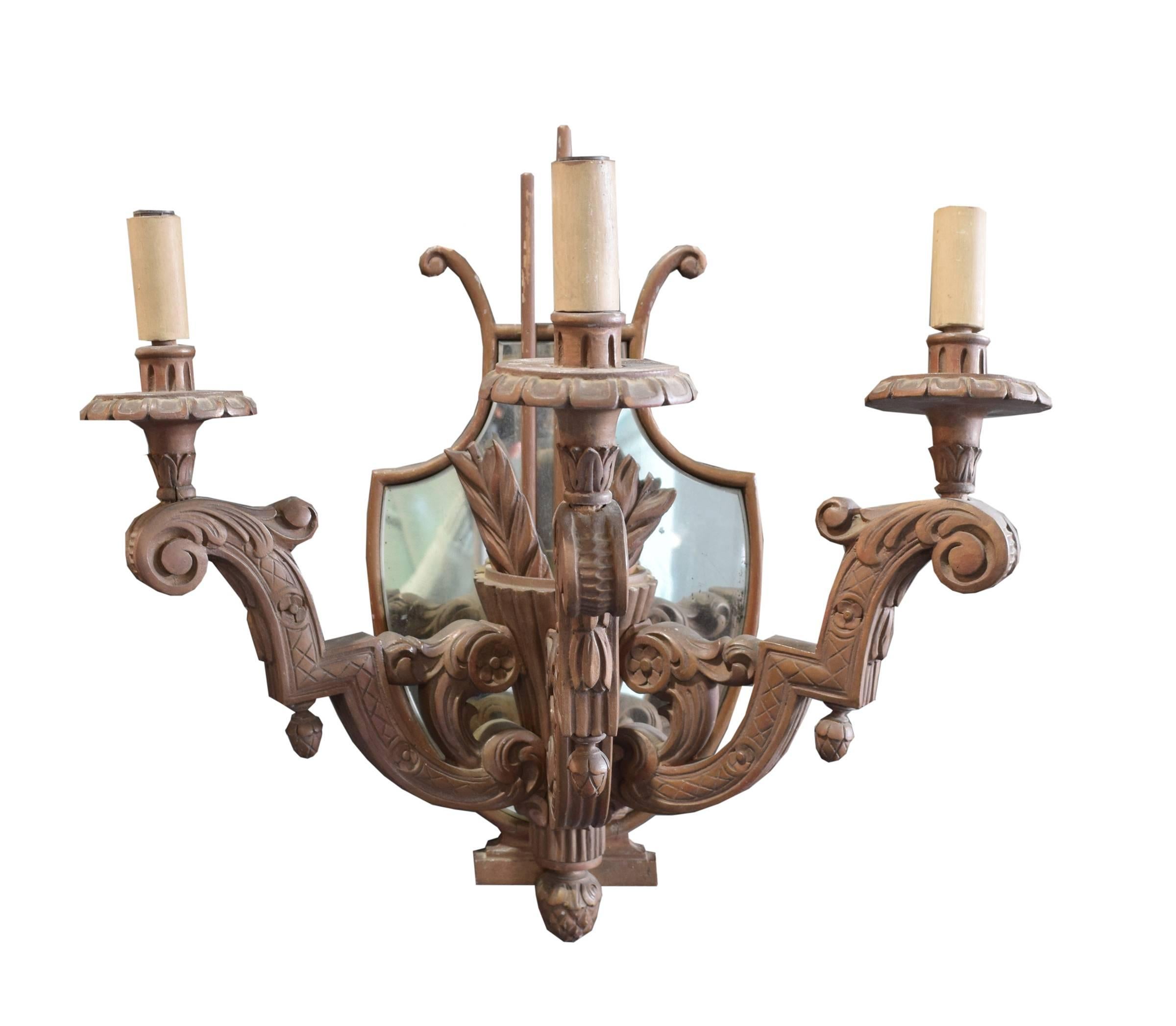 Pair of Argentine heavily carved three-arm wood sconces with quivers with arrows and mirrored backs, circa 1920. Needs to be wired.