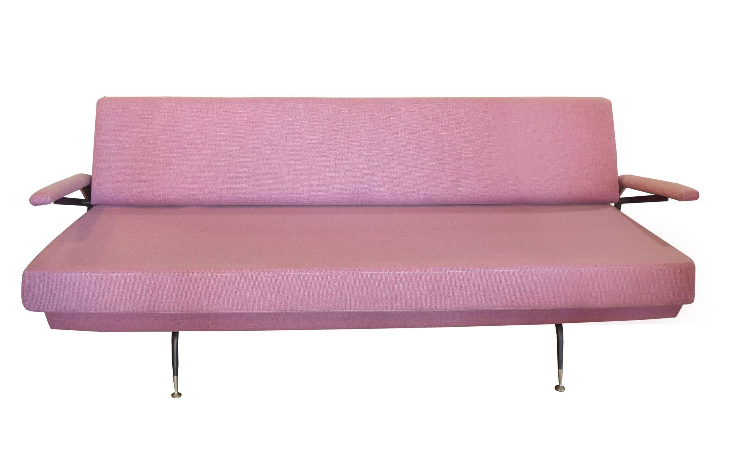 Italian sofa that converts into a day bed by lifting the armrests. This interesting, circa 1970 design is attributed to Osvaldo Borsani and is upholstered in a pink fabric with an iron frame and brass feet.