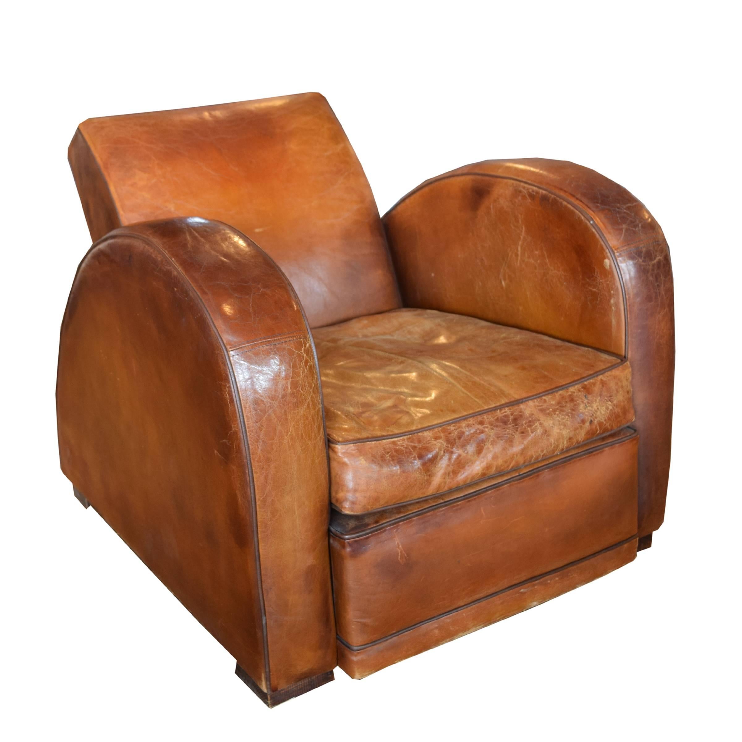 A French leather racecar club chair with a great patina, reclined back and dramatically curved sides, circa 1930.