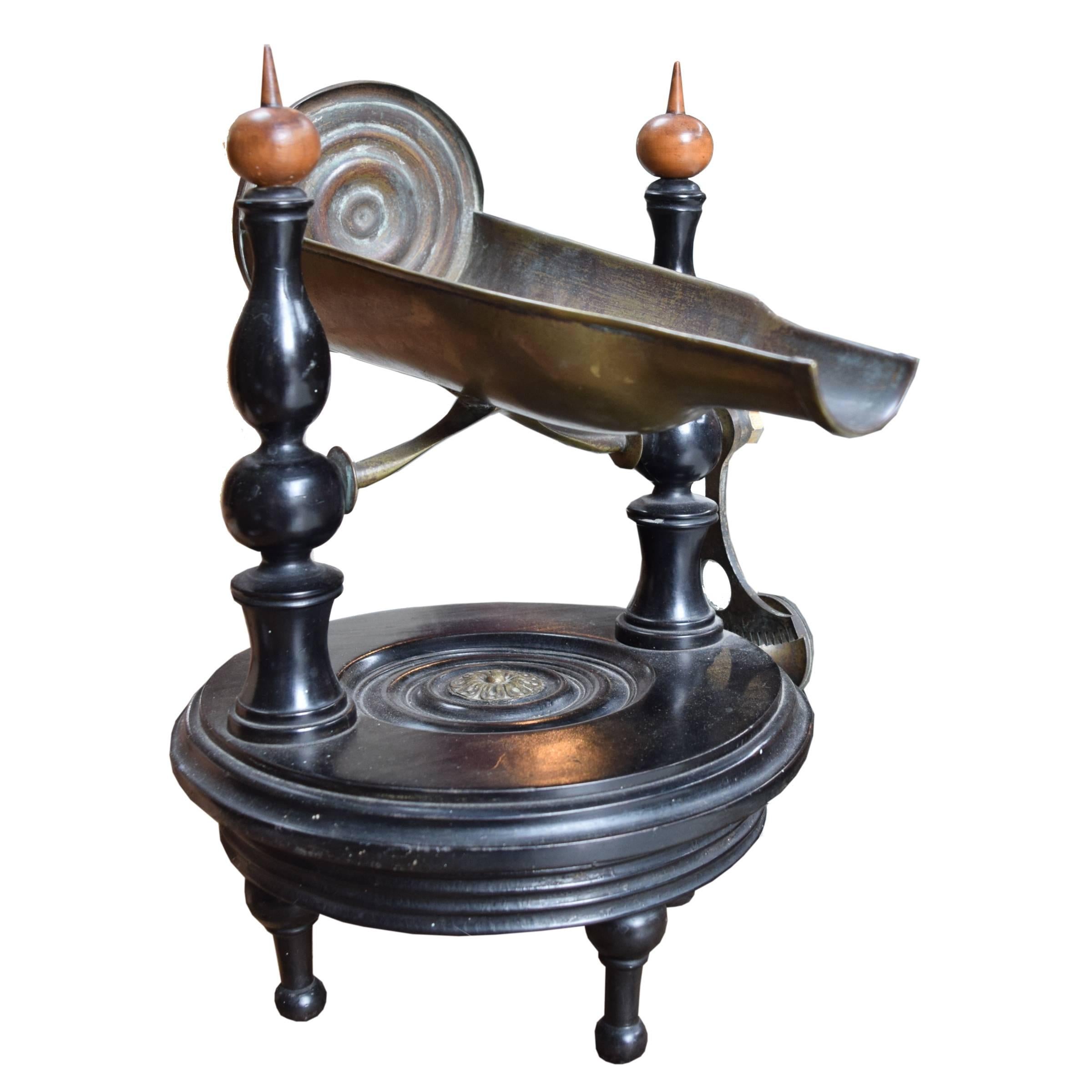 A lovely Italian mechanical wine server with a brass bottle cradle and wood base with spindled supports, and raised on three turned legs. Turning the knob activates the cradle, tilting it to achieve the perfect angle for pouring, late 19th century.