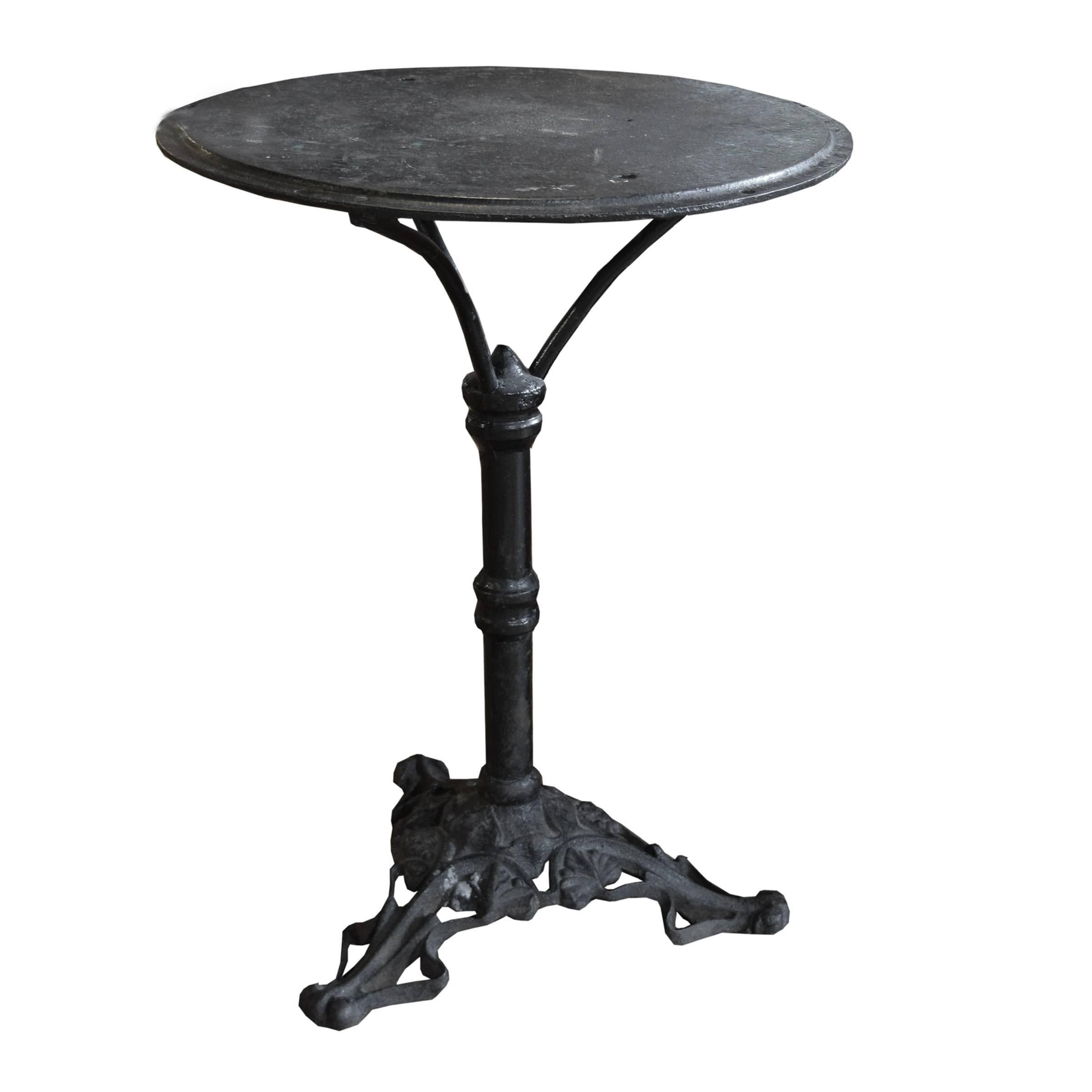 A fun French cast iron cafe table with a circular top raised on a pedestal base, ending on an Art Nouveau leaf and vine pattern tripod base, circa 1910.
  