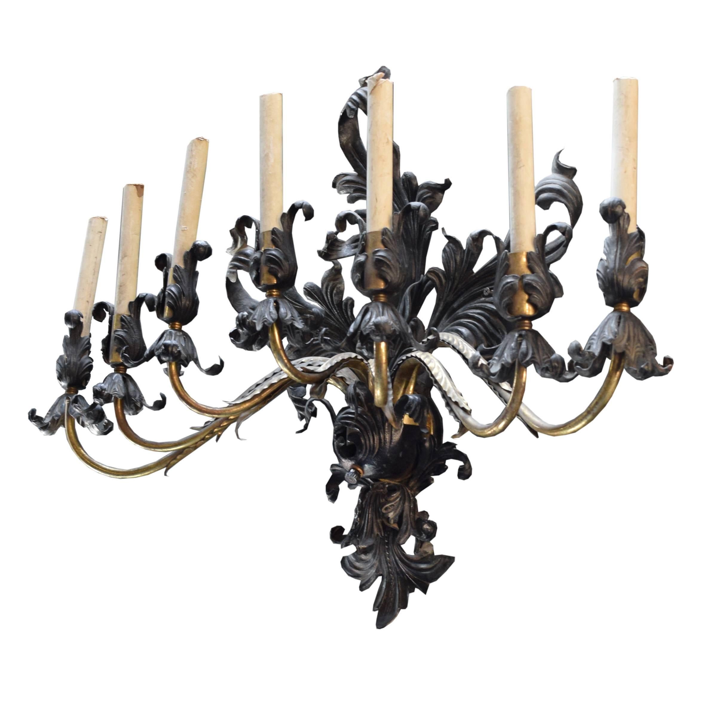 An American wall sconce having seven brass arms and iron acanthus leaf backplate and candle cup details, circa 1930.

Requires re-wiring.