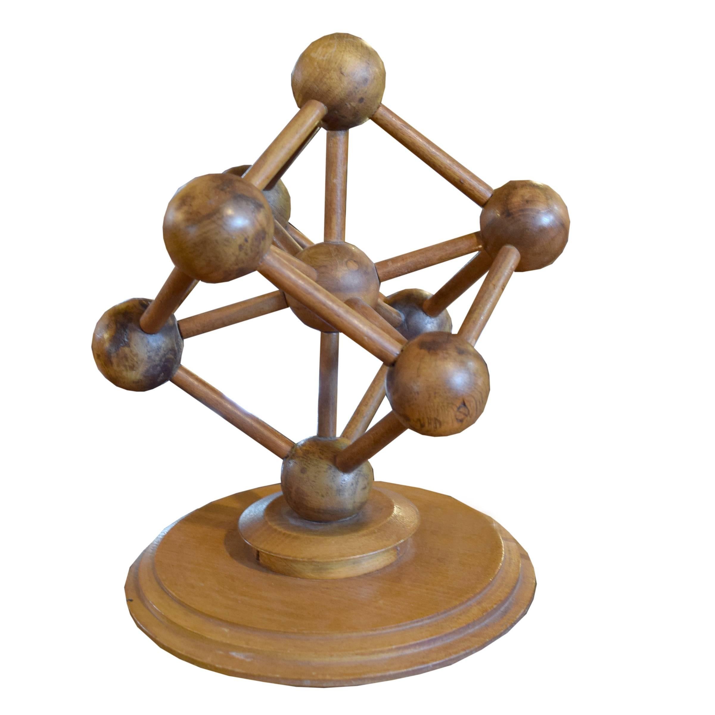 A German carved wood molecular model depicting nine atoms and 20 bonds, mounted on a turned wood base.
      