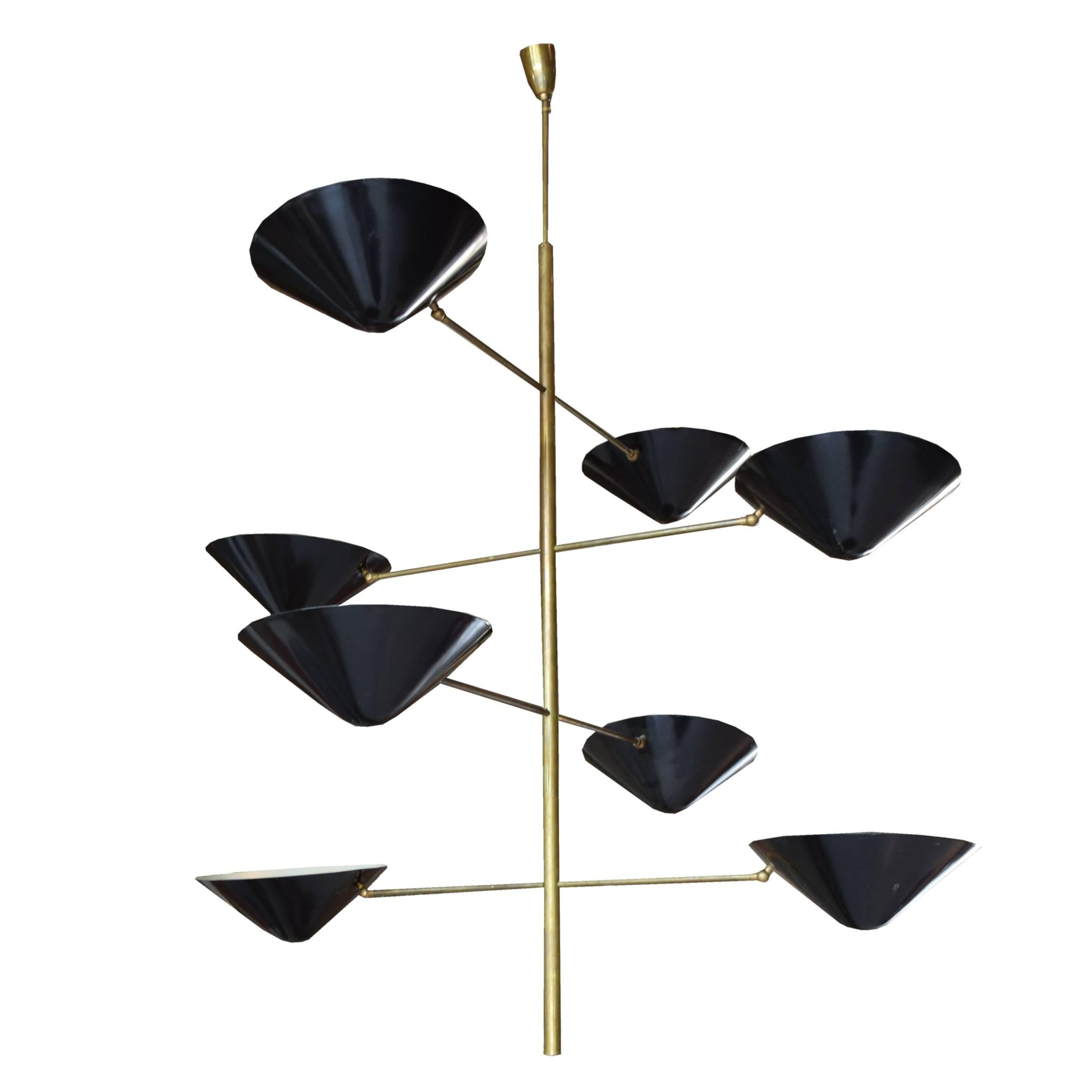 An Italian Mid-Century chandelier in the style of Stilnovo, with a brass frame and eight arms with adjustable black conical shades.
Pair available.

Requires re-wiring