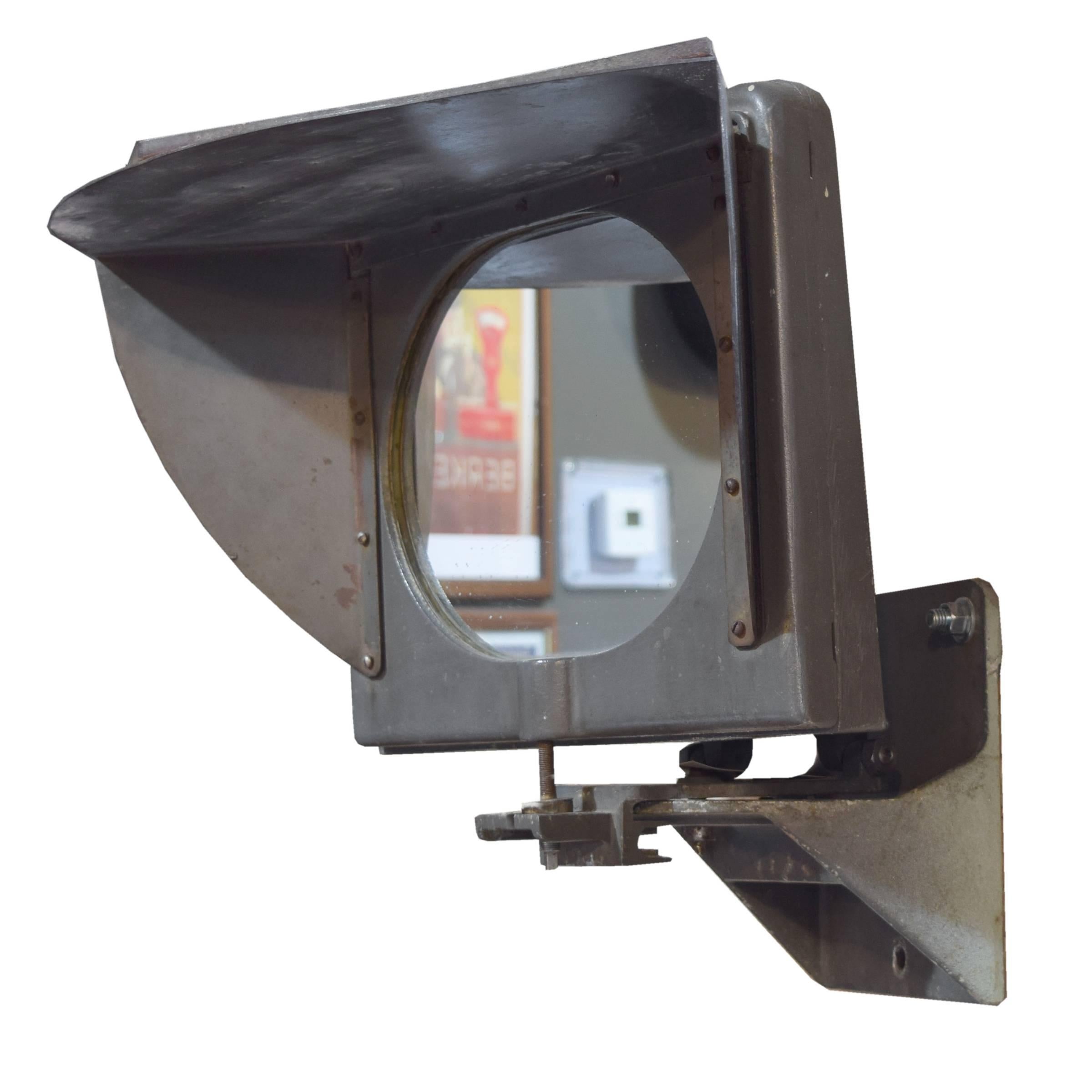 An American oval shaped mirror in an Industrial cast iron frame, base and visor that adjusts left and right.