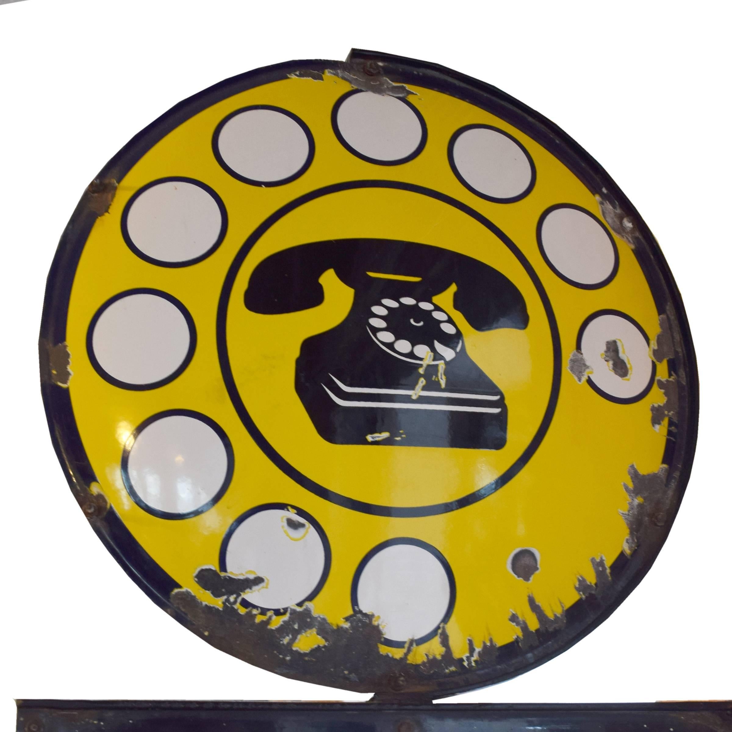 An Italian yellow and black enamel metal public telephone sign advertising 'interurbano automatico', or capabilities of making long distance calls without an operator, circa 1950.