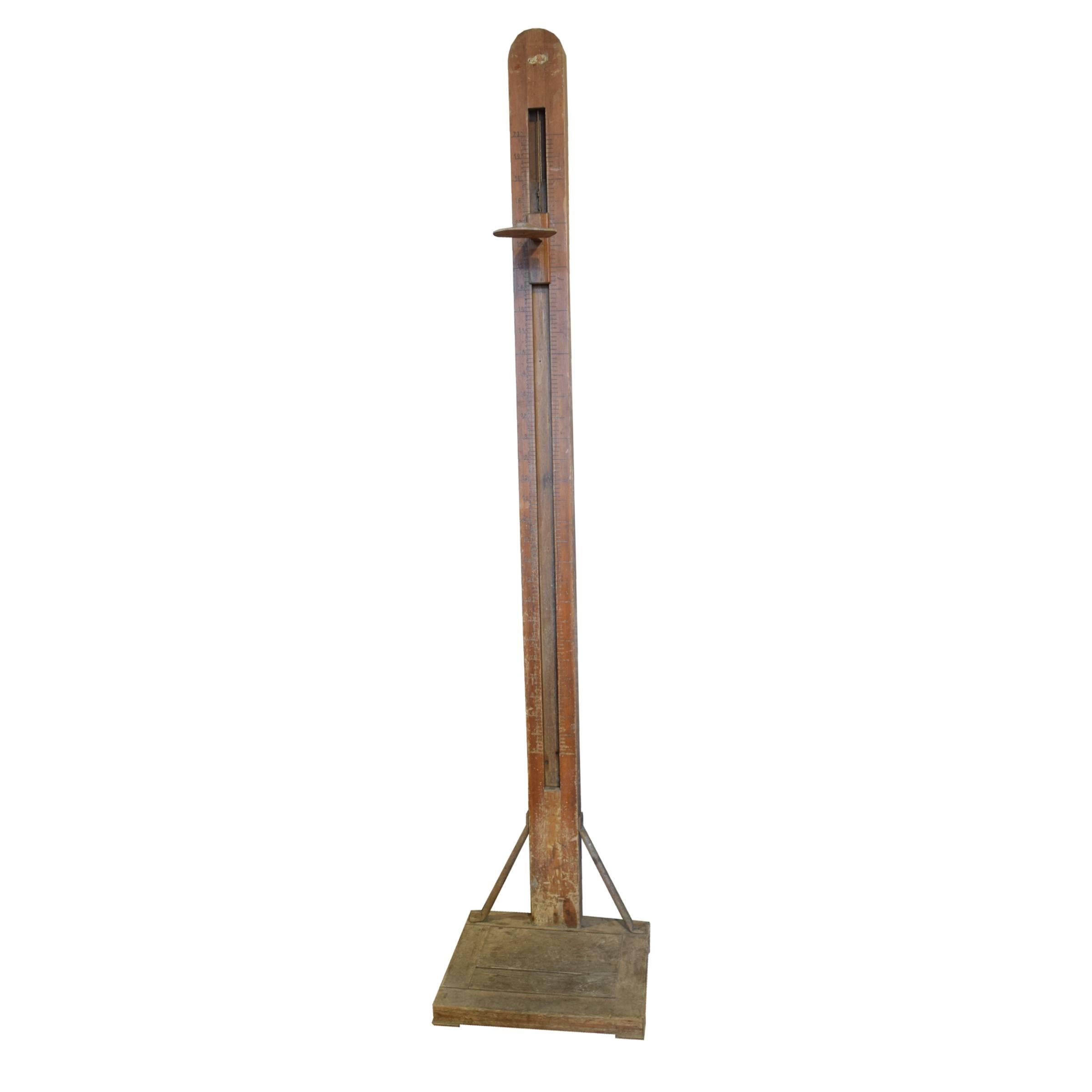A German wooden stadiometer with iron supports used for measuring human height, from a gymnasium locker room, circa 1900.