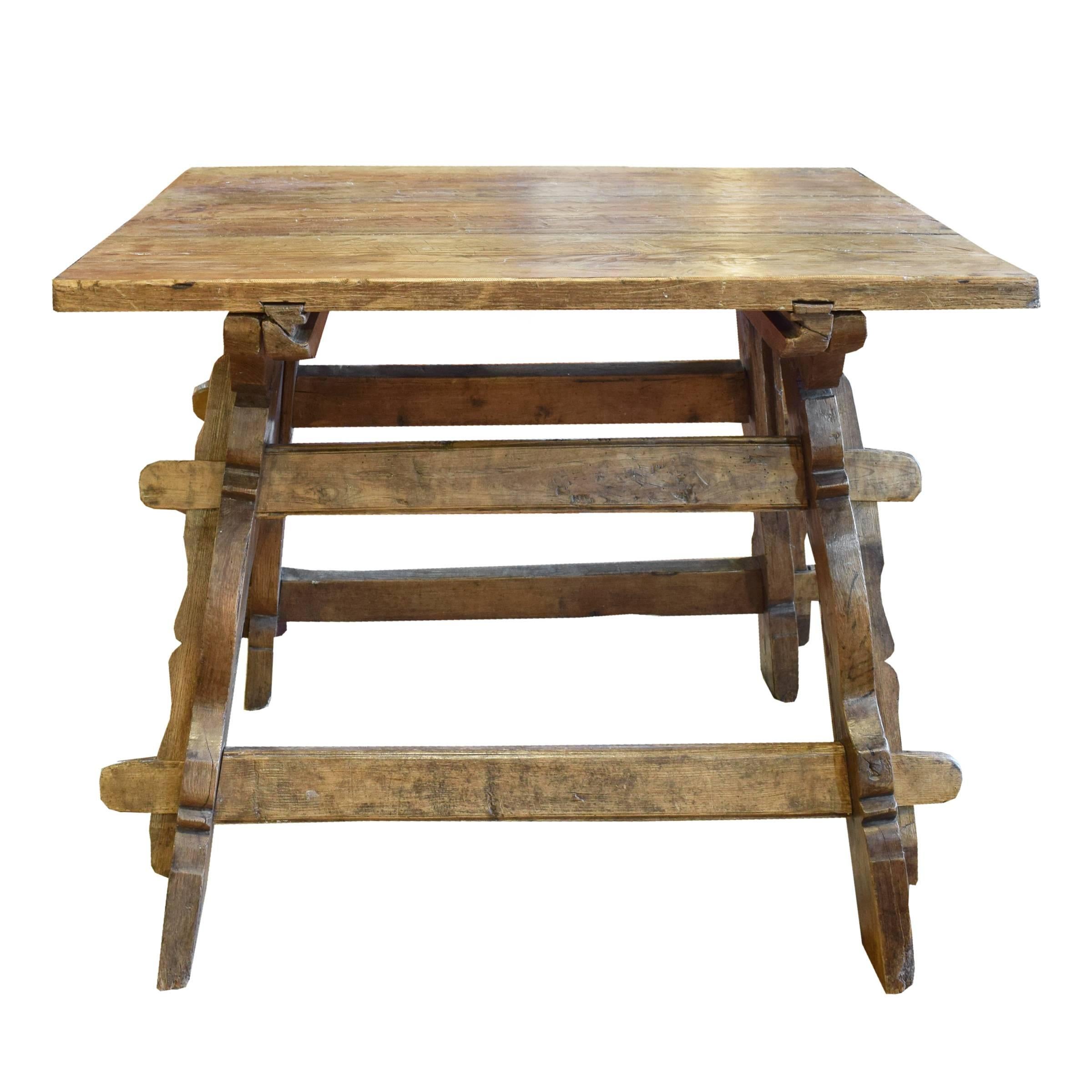A rare Bavarian Jogl table with a thick wood top, A-frame legs with pregged double stretchers and a carved apron on one side, 19th century.