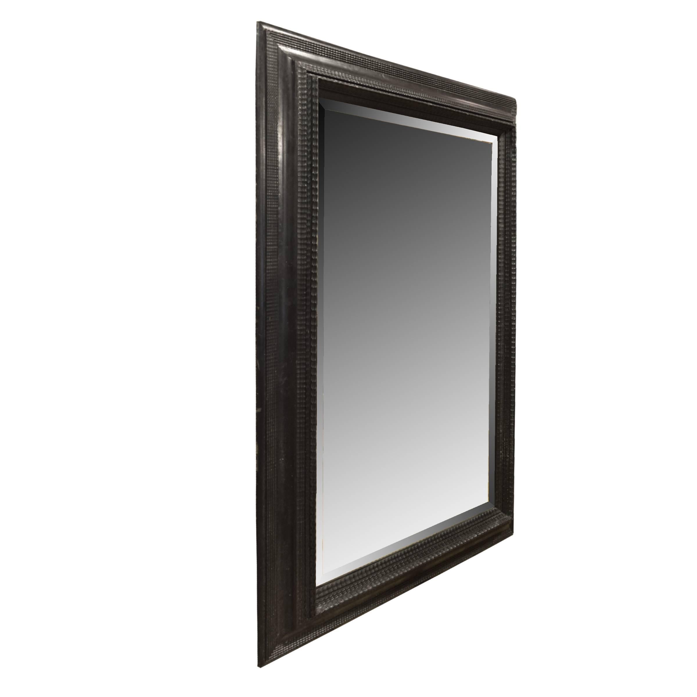 An Italian 19th century ebonized carved wood frame with a beveled mirror.
