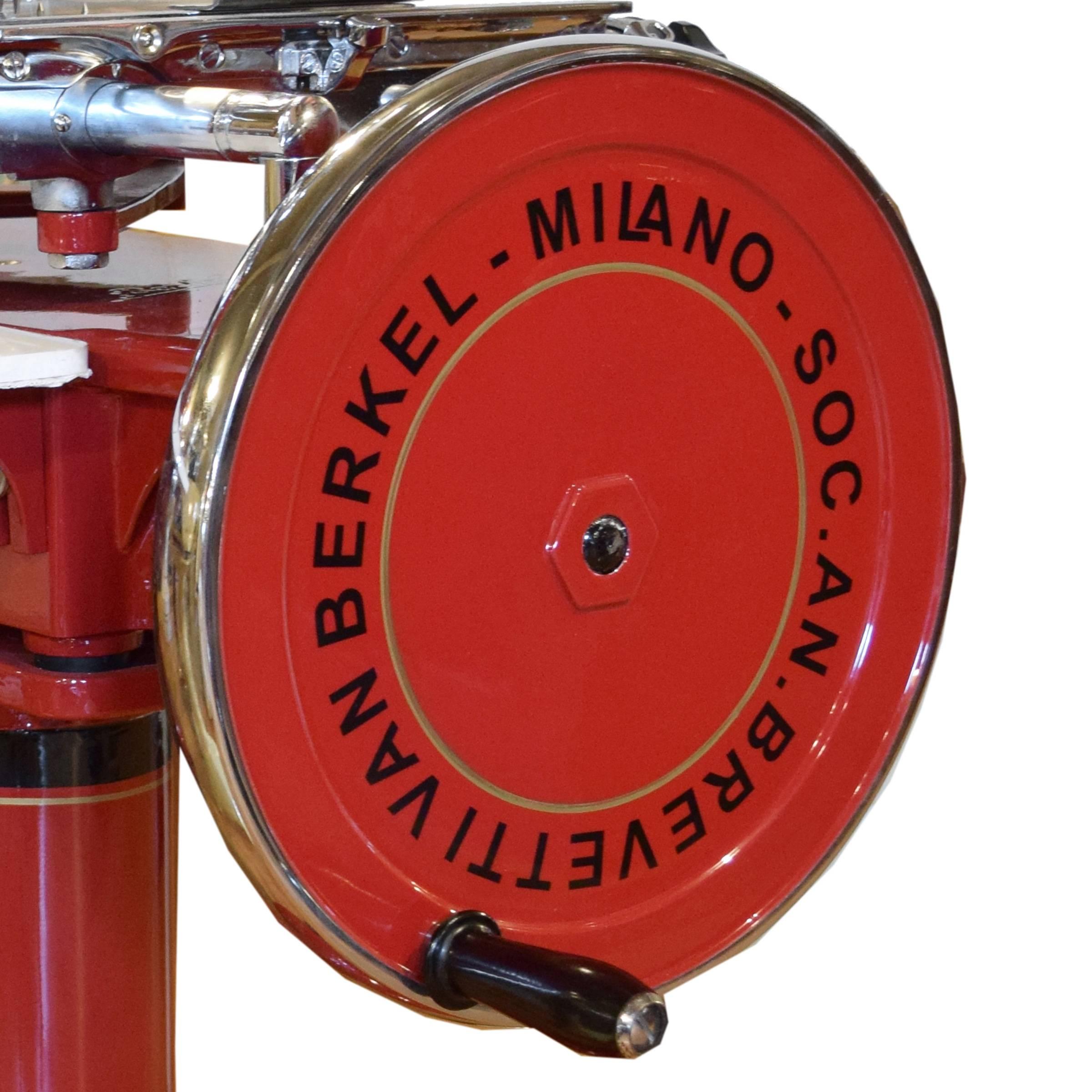 A rare Berkel model ten meat slicer in a red high gloss enamel with black and gold pinstriping, manufactured in Milan, Italy. This model from circa 1950 is flywheel operated and features 15 different slicing thicknesses and a blade sharpener. This