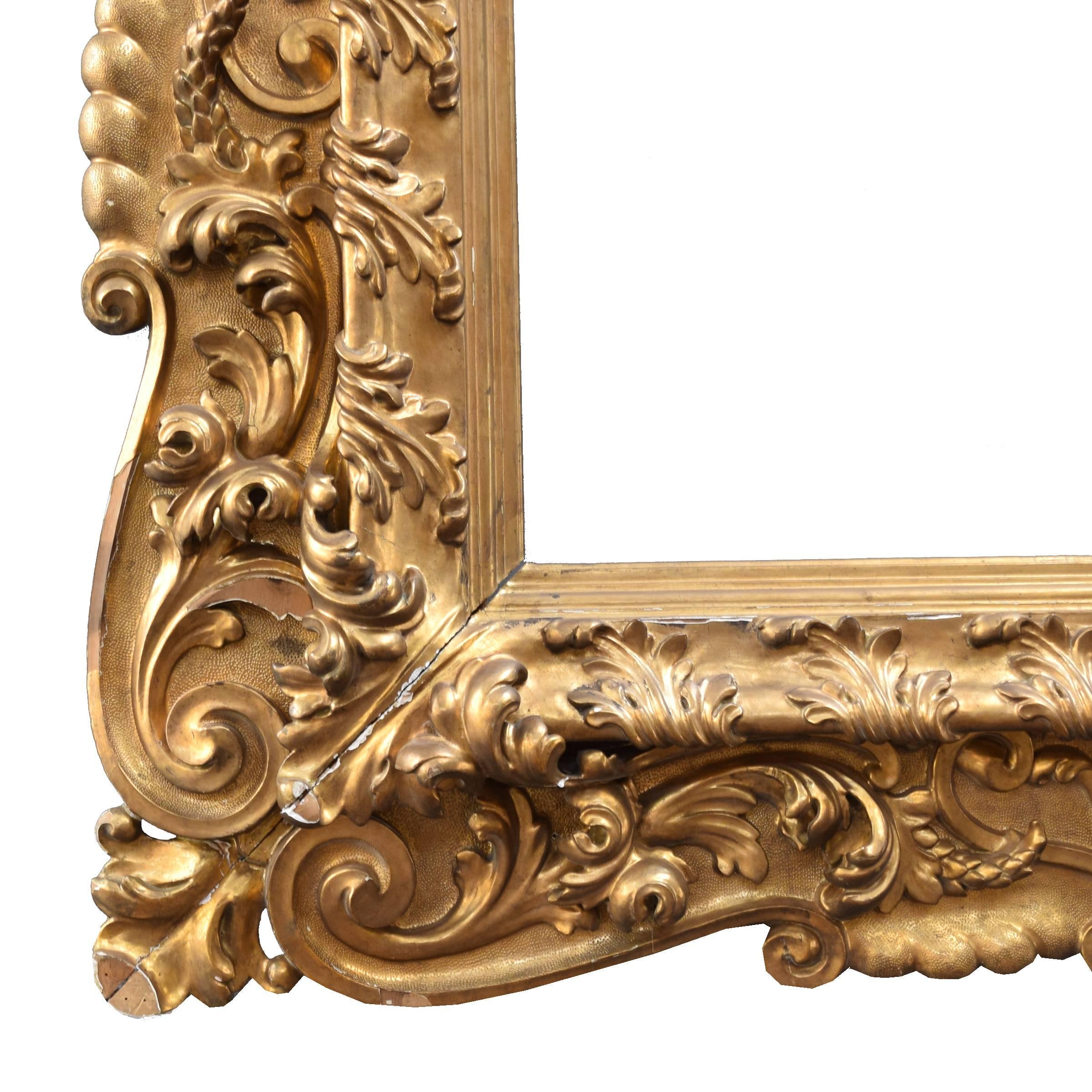 A monumental American carved wood and water gilt frame with a scrolling acanthus leaf pattern.
   