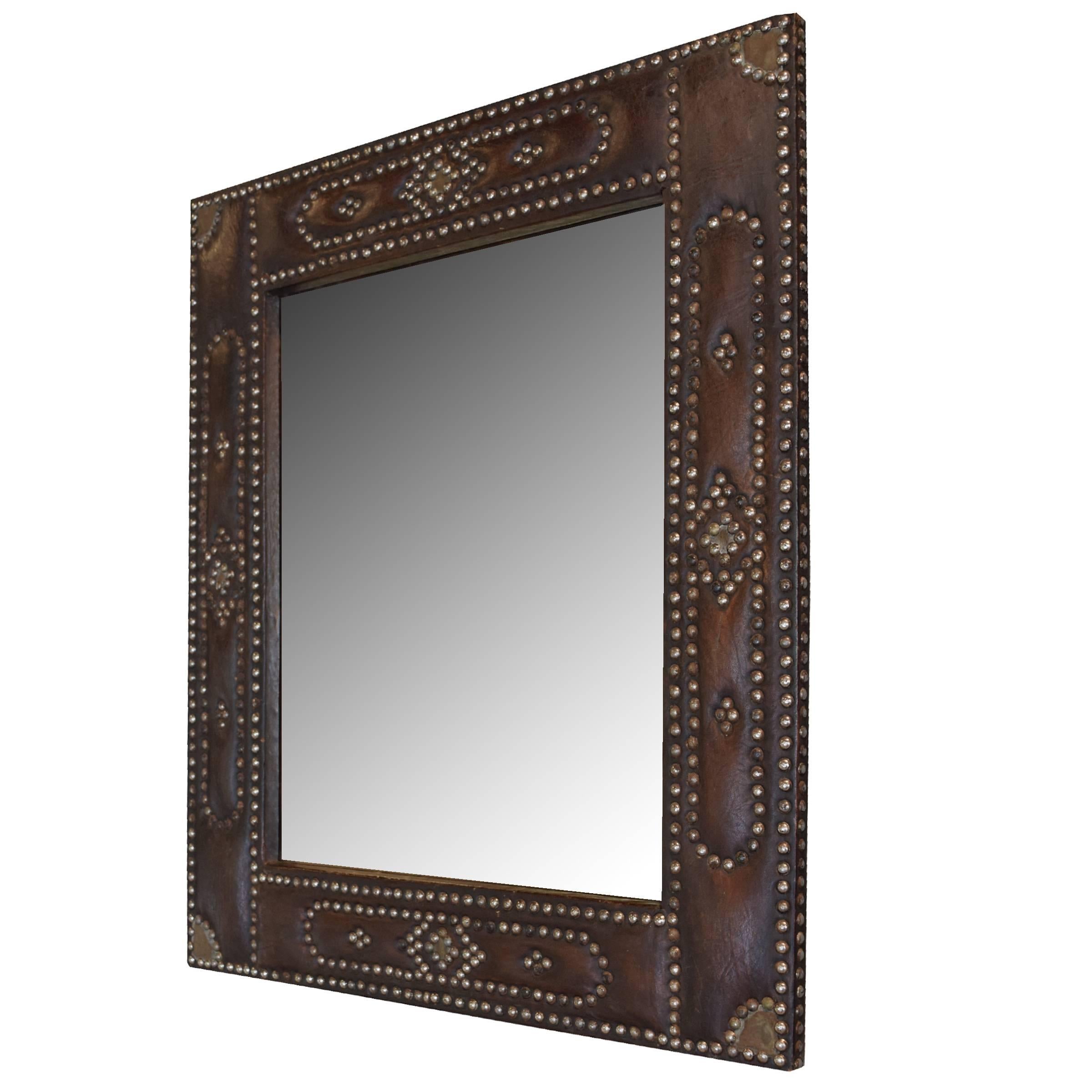 A French mirror with a leather frame and decorative brass nailhead detailing.
 