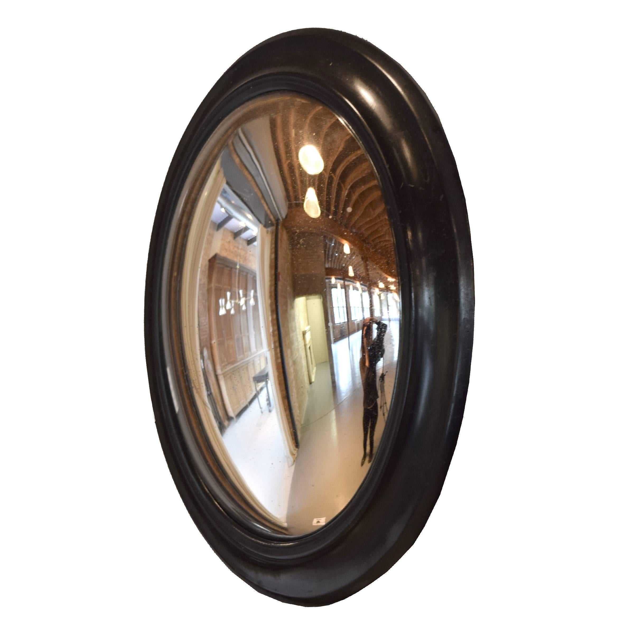 A fabulous French oval convex mirror with an ebonized frame, 19th century.
   